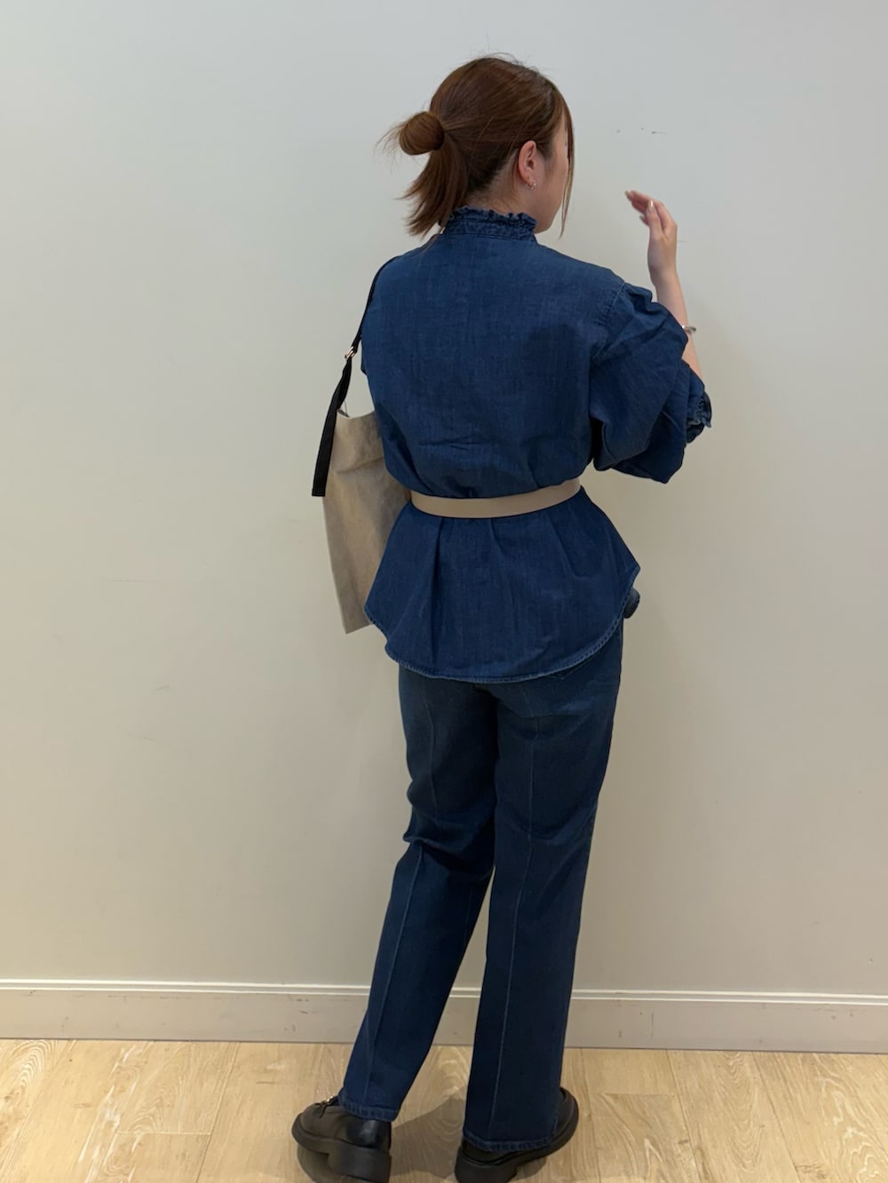 ブラック系のバックパック/リュック、ブルー系のシャツ/ブラウス、ブルー系のデニムパンツを着用したレディースの夏コーディネートの2枚目の写真