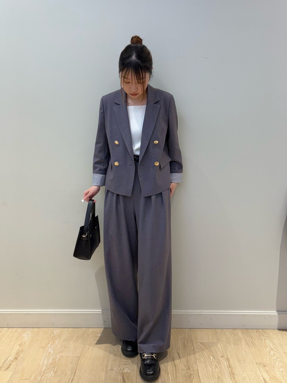 ブラック系のショルダーバッグ、ホワイト系のタンクトップ、グレー系のテーラードジャケットを着用したレディースの秋コーディネートの4枚目の写真