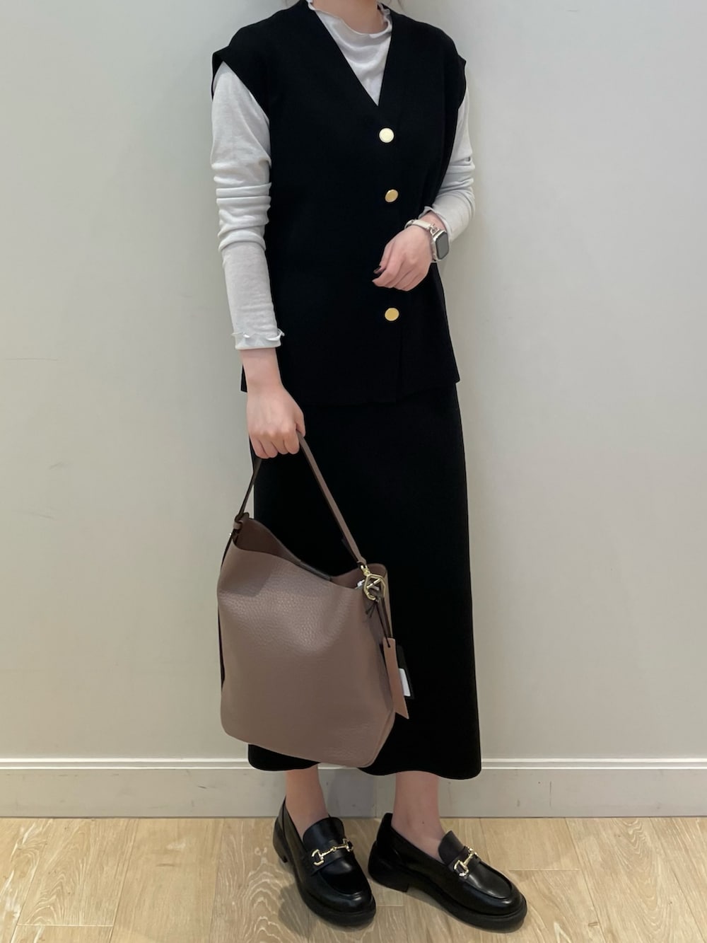 ブラック系のニット/セーター、ベージュ系のショルダーバッグ、シルバー系のTシャツ/カットソーを着用したレディースの冬コーディネートの2枚目の写真