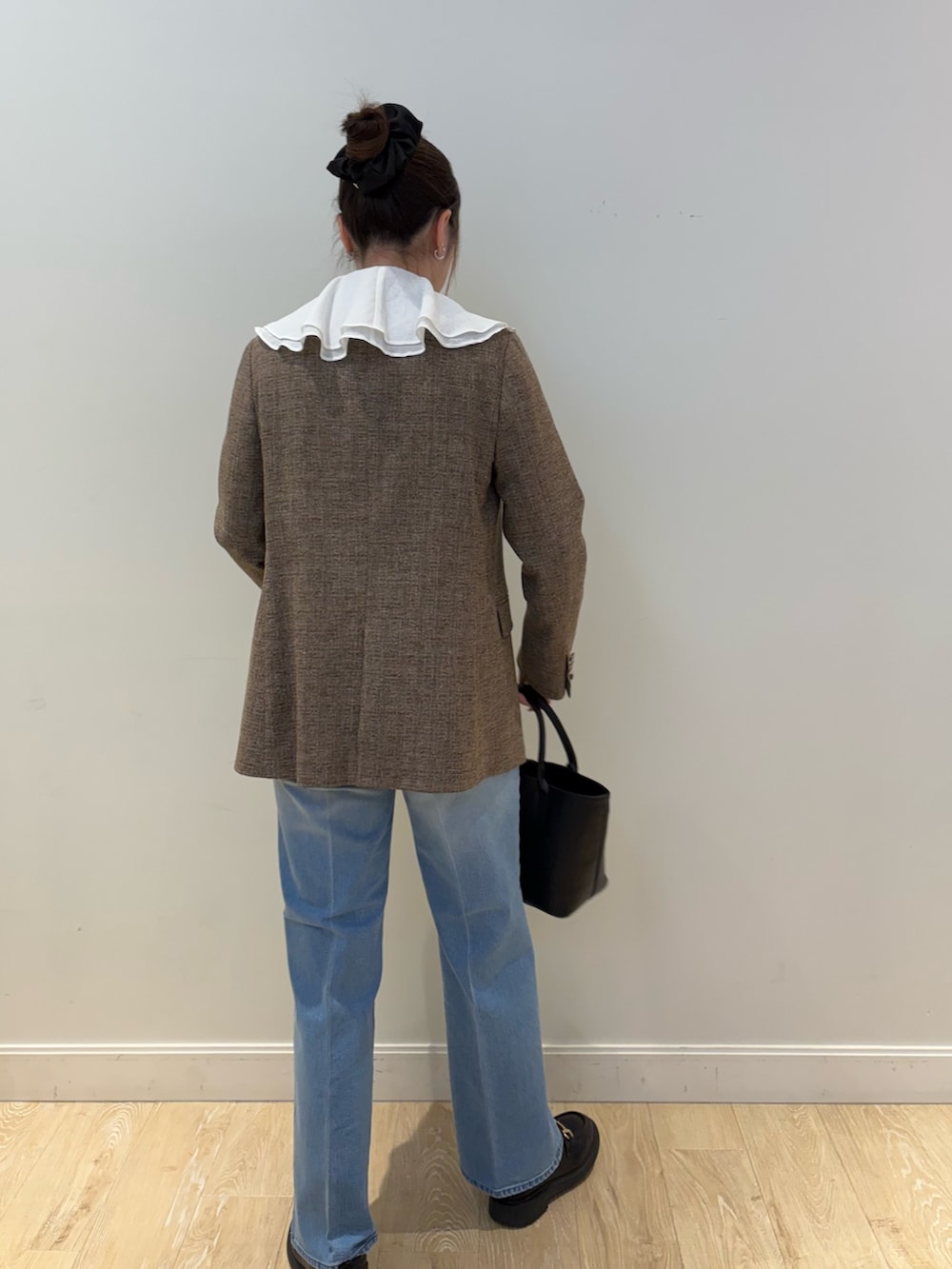 ブラック系のタンクトップ、ブルー系のテーラードジャケット、ブラック系のトートバッグを着用したレディースの冬コーディネートの2枚目の写真