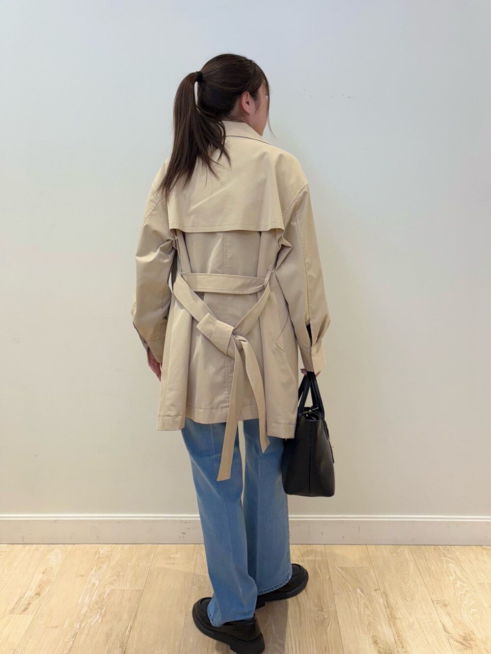 ブラック系のトートバッグ、ブルー系のデニムパンツ、ブルー系のニット/セーターを着用したレディースの冬コーディネートの2枚目の写真