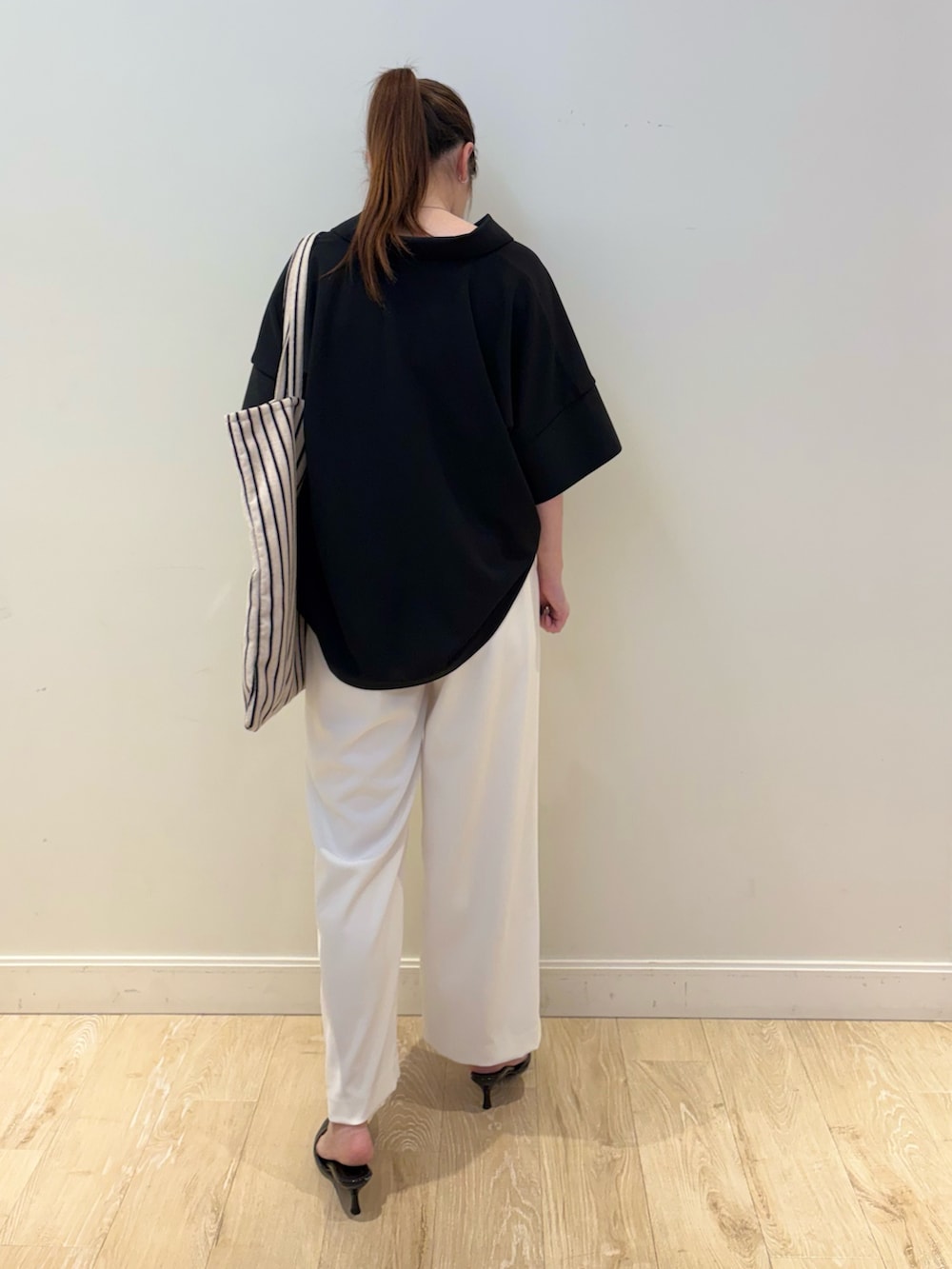 ホワイト系のその他パンツ、ベージュ系のバックパック/リュック、ブラック系のポロシャツを着用したレディースの春コーディネートの2枚目の写真