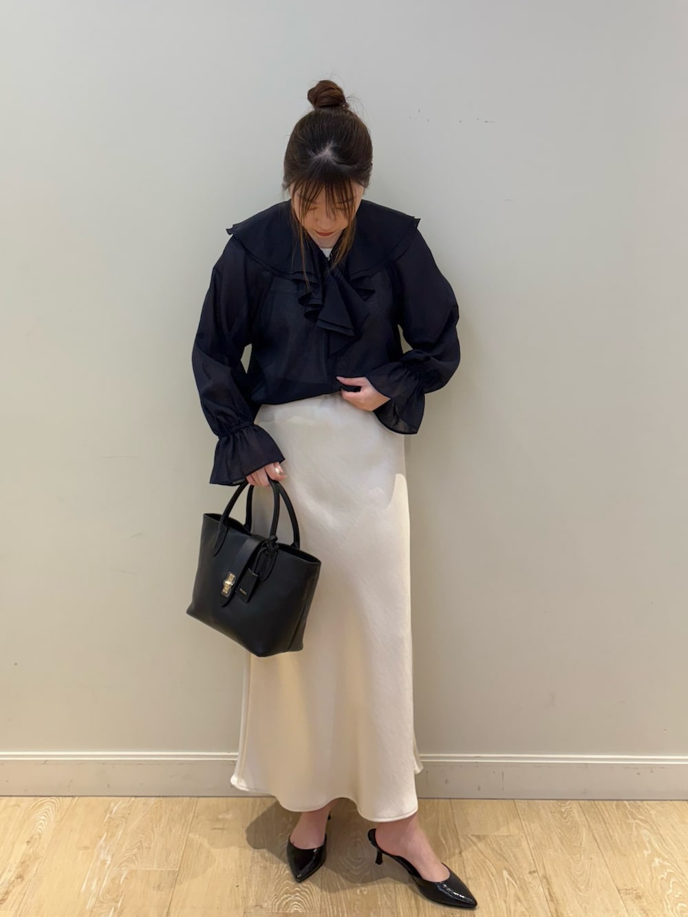 ブラック系のトートバッグ、ホワイト系のタンクトップ、ブルー系のシャツ/ブラウスを着用したレディースの春コーディネートの4枚目の写真