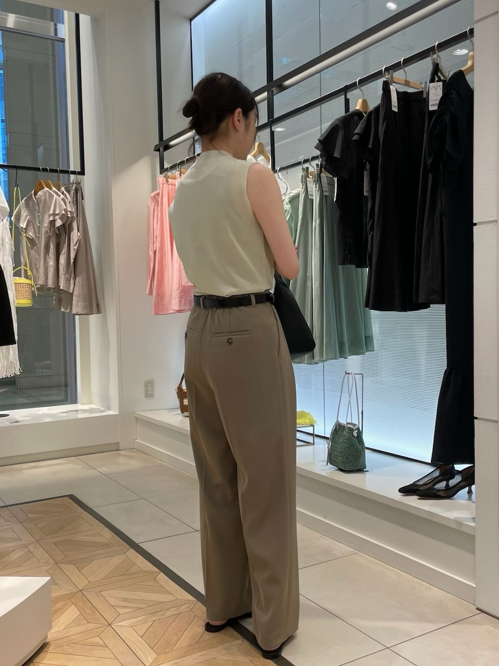 ゴールド系のニット/セーター、グリーン系のその他パンツ、ブラック系のショルダーバッグを着用したレディースの春コーディネートの5枚目の写真