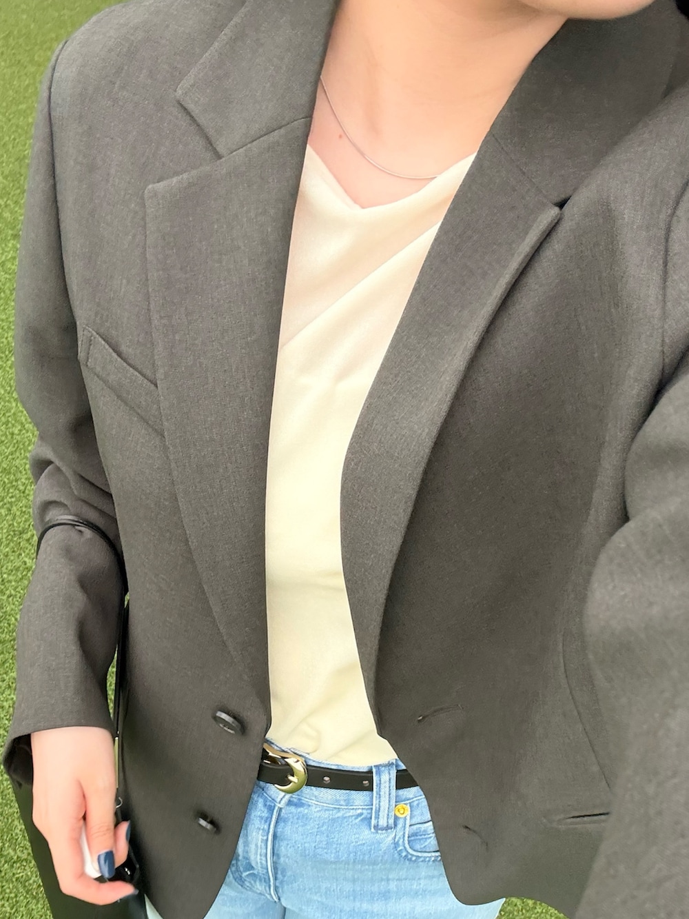 ブラック系のショルダーバッグ、ブルー系のデニムパンツ、ピンク系のTシャツ/カットソーを着用したレディースの秋コーディネートの4枚目の写真