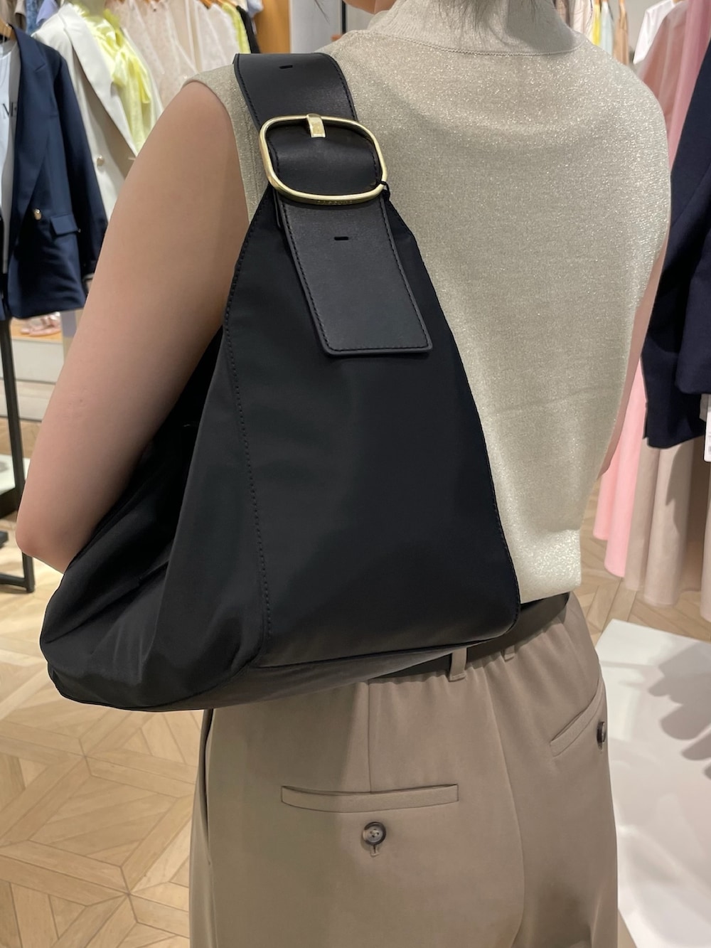 ゴールド系のニット/セーター、グリーン系のその他パンツ、ブラック系のショルダーバッグを着用したレディースの春コーディネートの8枚目の写真