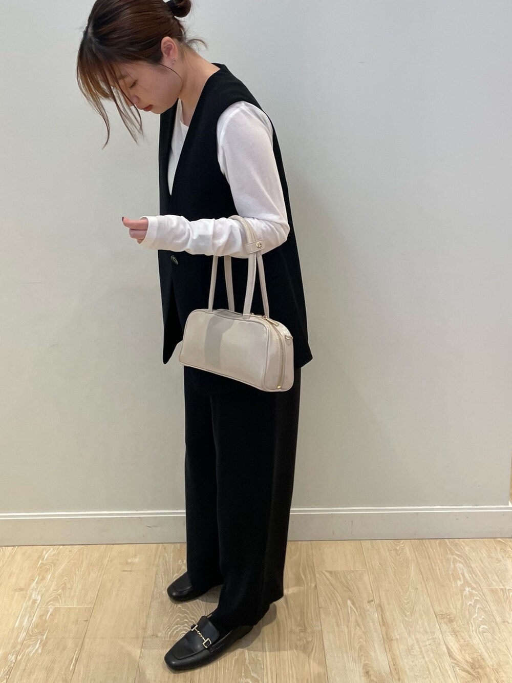 ブラック系のその他パンツ、ホワイト系のTシャツ/カットソー、ブラック系のベストを着用したレディースの秋コーディネートの3枚目の写真