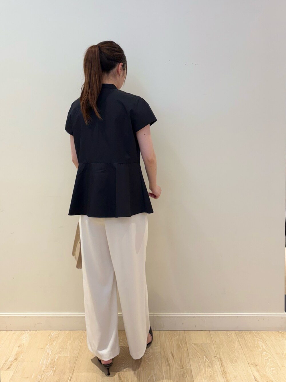 ベージュ系のトートバッグ、ホワイト系のその他パンツ、ブラック系のシャツ/ブラウスを着用したレディースの春コーディネートの3枚目の写真