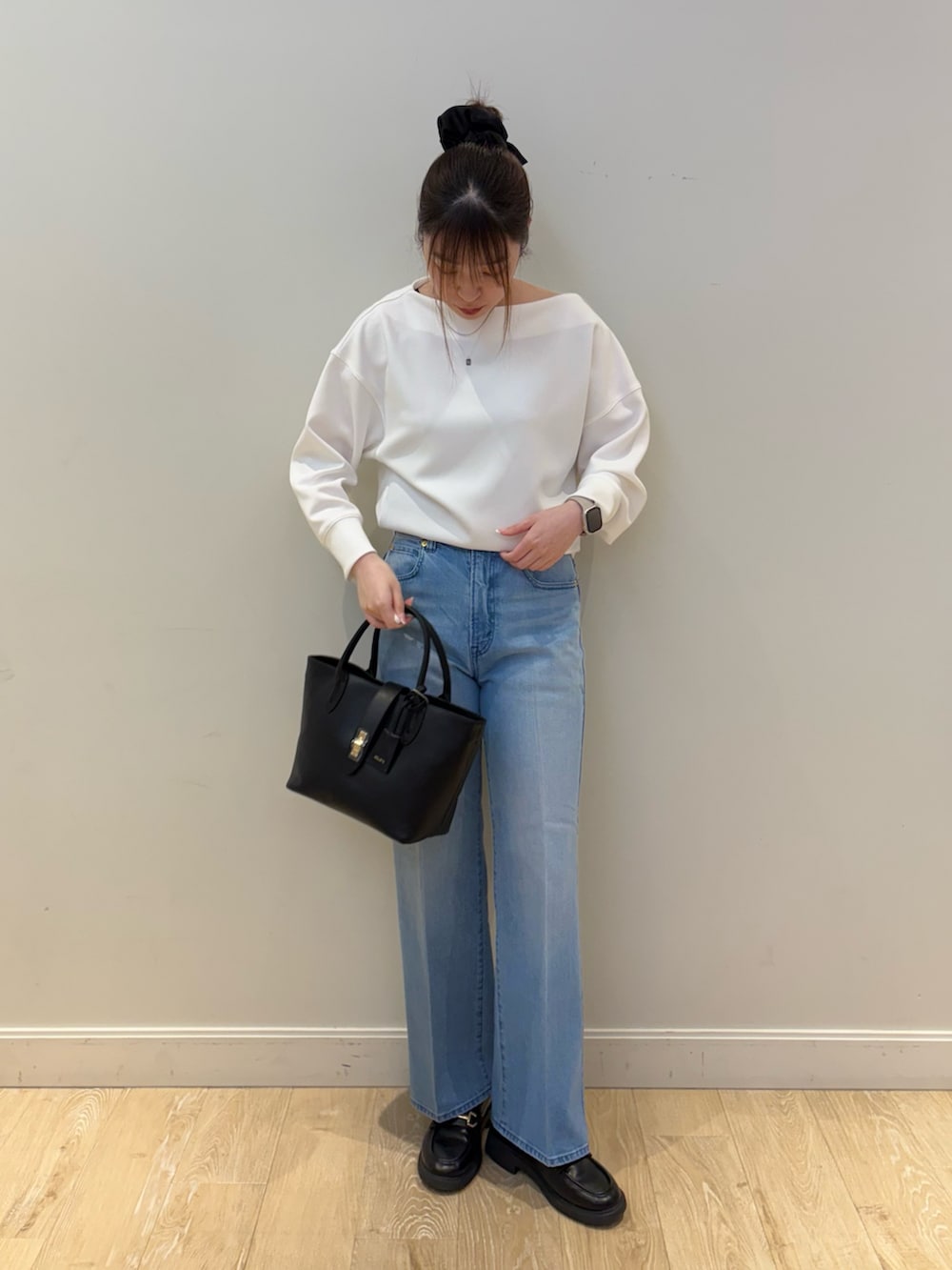 ブラック系のトートバッグ、ブルー系のデニムパンツ、ホワイト系のTシャツ/カットソーを着用したレディースの冬コーディネートの4枚目の写真