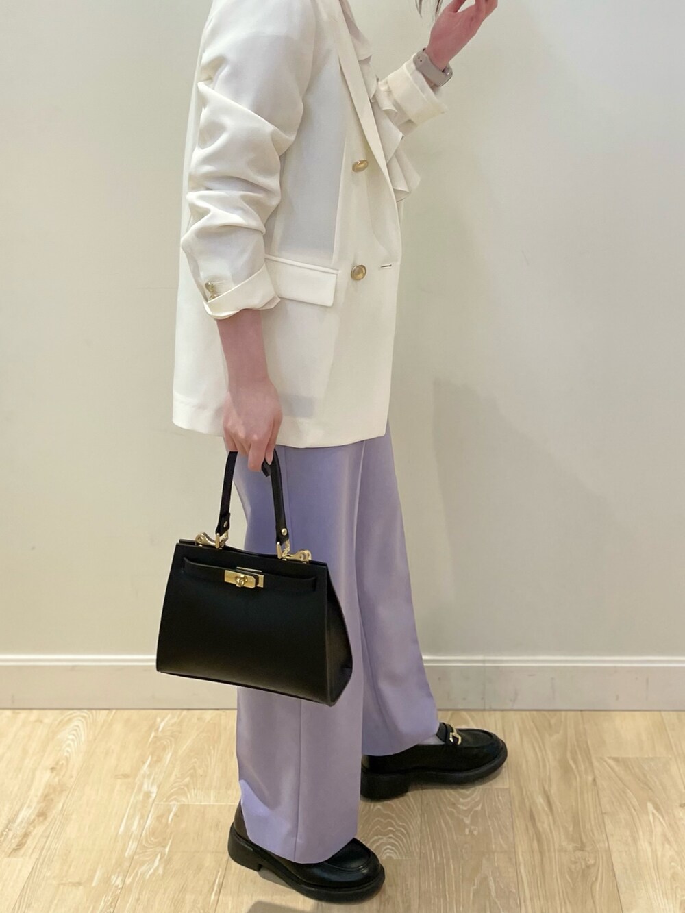ブラック系のショルダーバッグ、ブルー系のシャツ/ブラウス、ホワイト系のテーラードジャケットを着用したレディースの春コーディネートの2枚目の写真