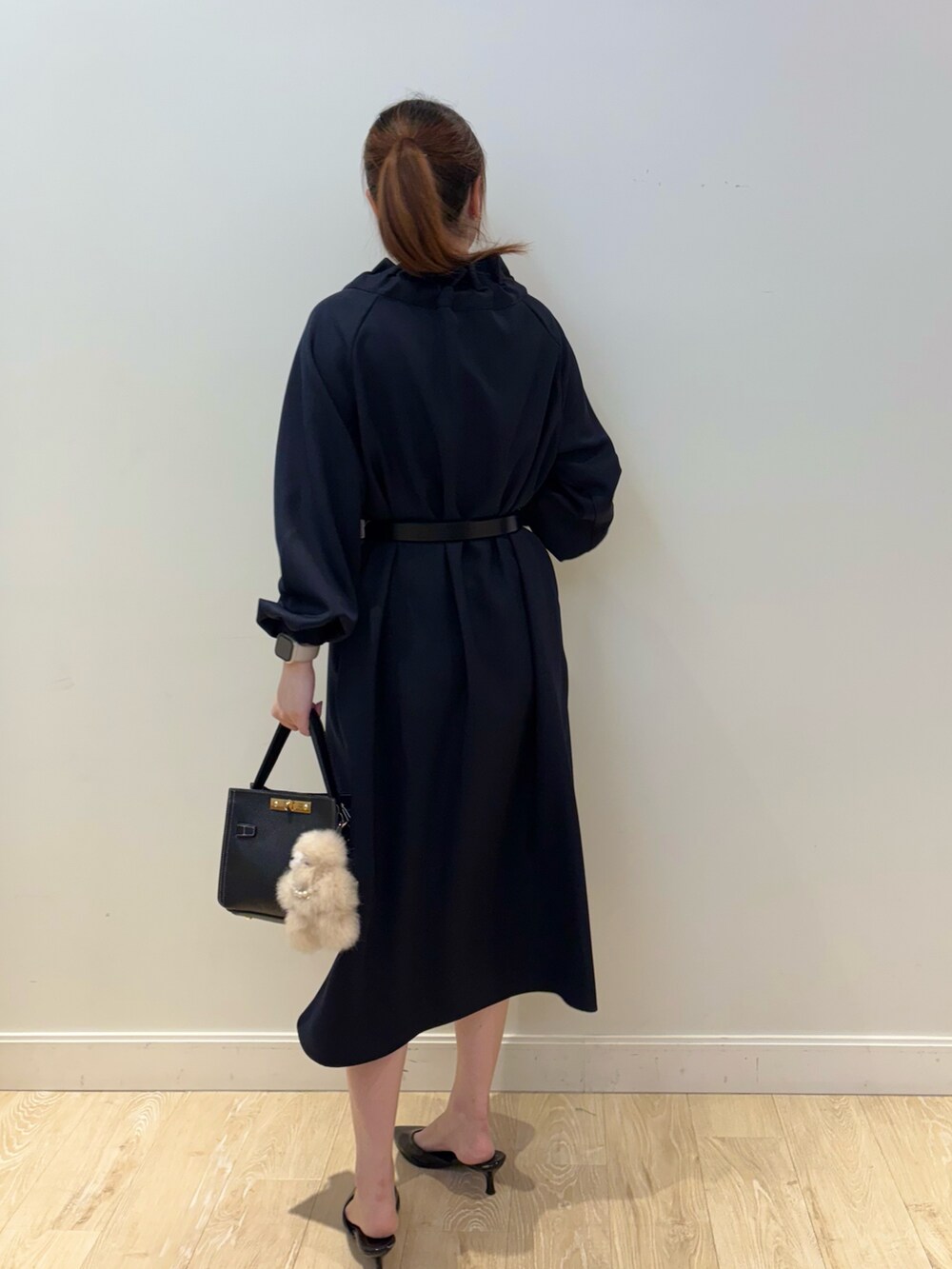 ブラック系のショルダーバッグ、ブルー系のワンピース、ブラック系のベルトを着用したレディースの秋コーディネートの3枚目の写真