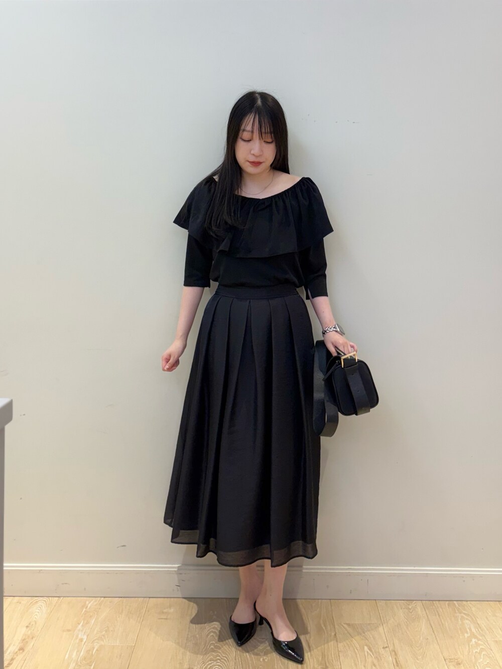 ブラック系のショルダーバッグ、ブラック系のTシャツ/カットソー、ブラック系のスカートを着用したレディースの夏コーディネートの5枚目の写真