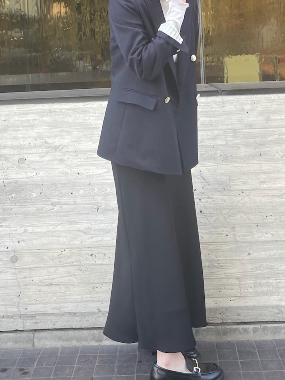 シルバー系のTシャツ/カットソー、ブラック系のスカート、ブルー系のテーラードジャケットを着用したレディースの冬コーディネートの5枚目の写真