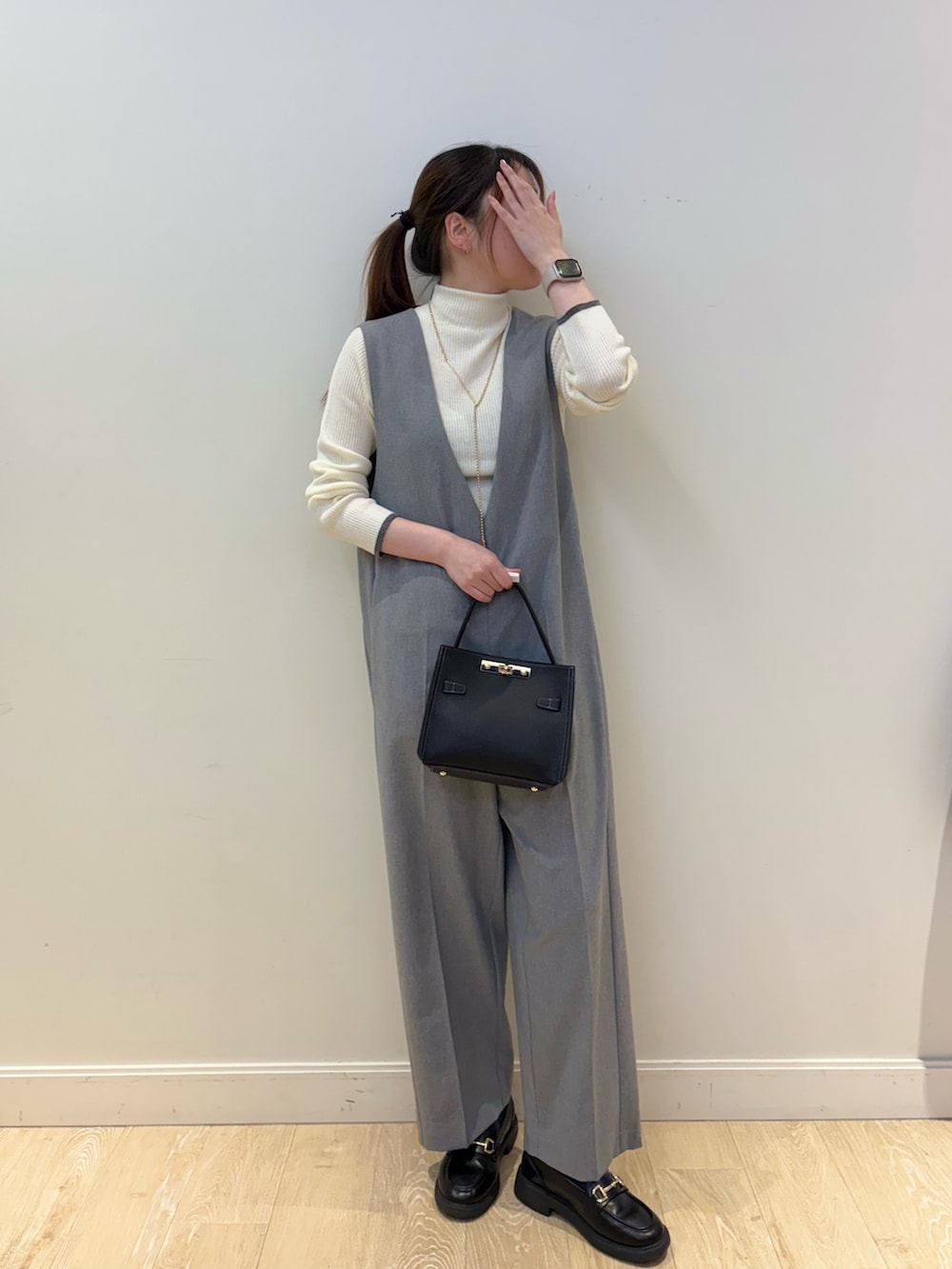 ブラック系のショルダーバッグ、ホワイト系のその他トップス、グレー系のつなぎ/オールインワンを着用したレディースの冬コーディネートの4枚目の写真
