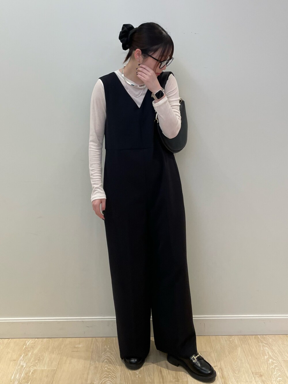 ブラック系のサロペット/オーバーオール、ブラック系のショルダーバッグ、ホワイト系のTシャツ/カットソーを着用したレディースの冬コーディネートの3枚目の写真