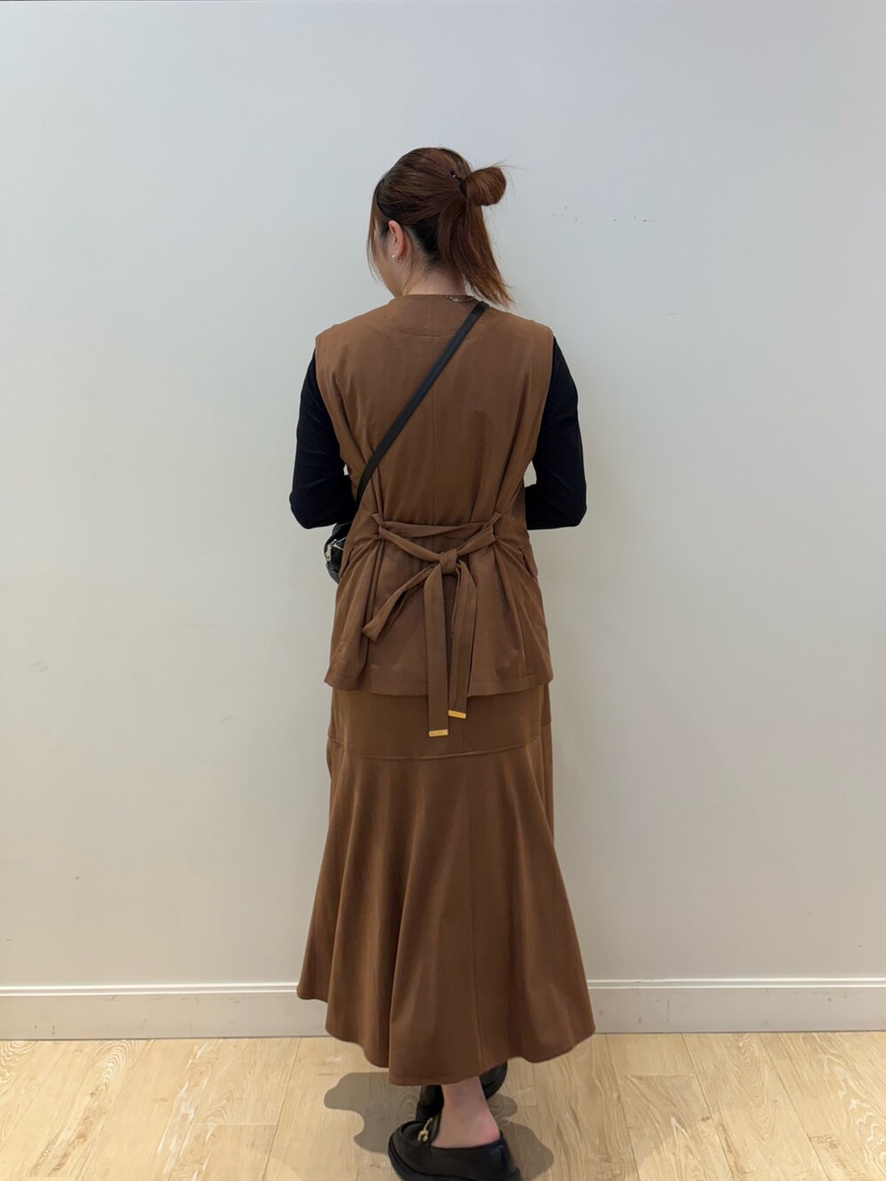 ブラウン系のスカート、その他のショルダーバッグ、ブラウン系のベストを着用したレディースの秋コーディネートの2枚目の写真