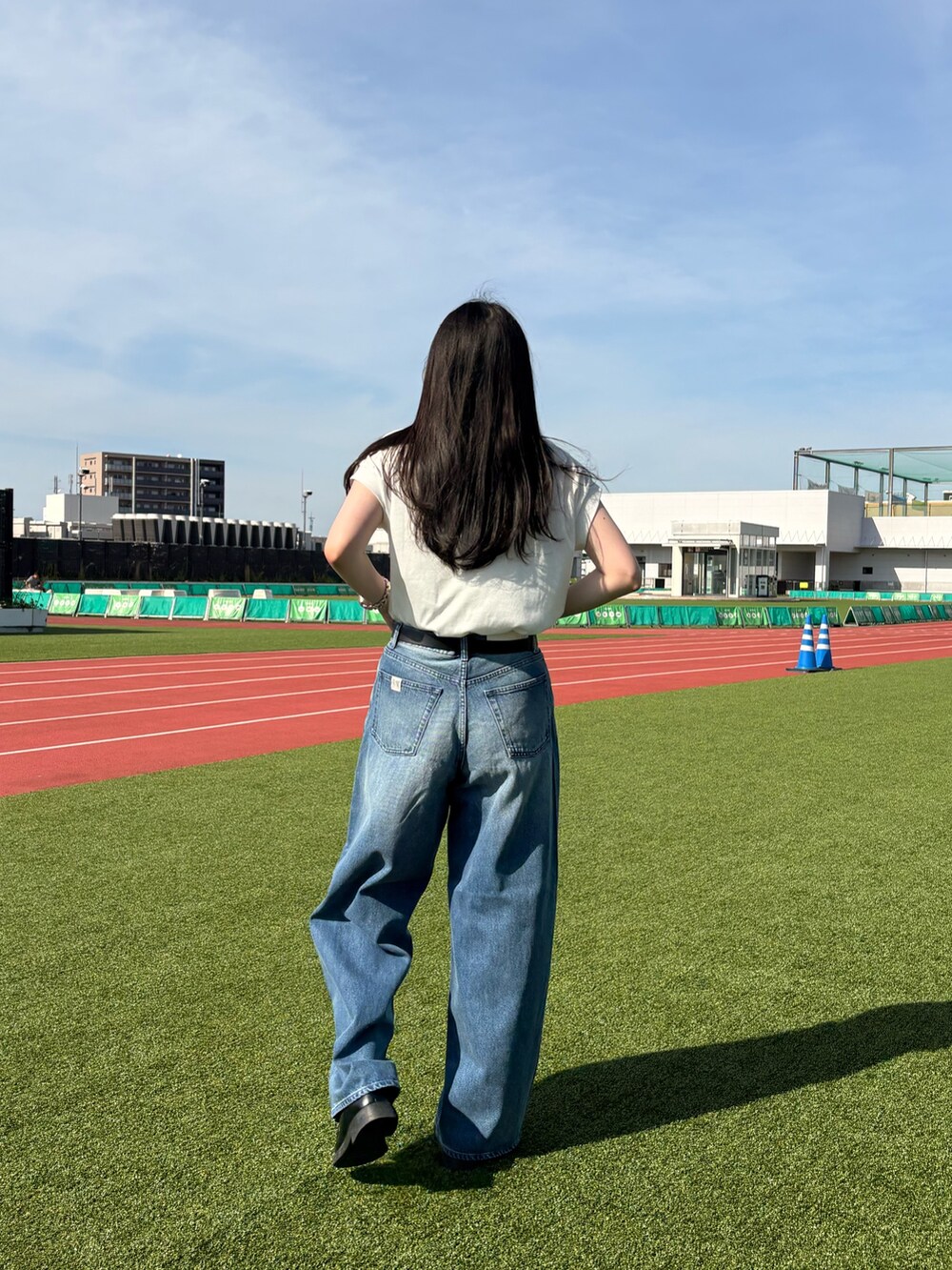 ホワイト系のTシャツ/カットソー、ブルー系のデニムパンツ、ブラック系のベルトを着用したレディースの夏コーディネートの3枚目の写真