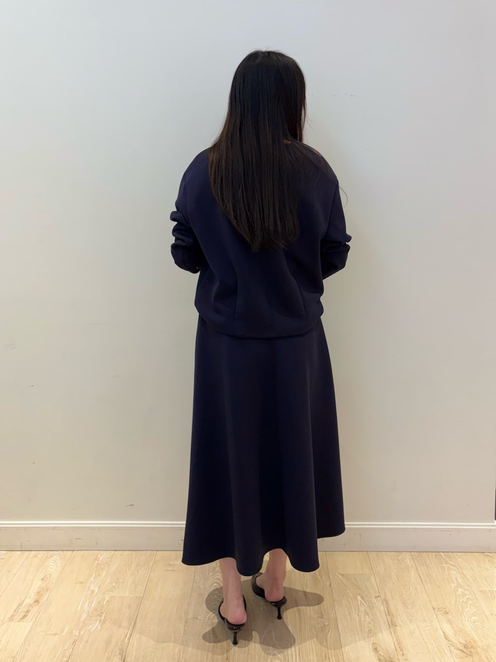 ブラック系のショルダーバッグ、ブルー系のTシャツ/カットソー、ブルー系のスカートを着用したレディースの秋コーディネートの2枚目の写真