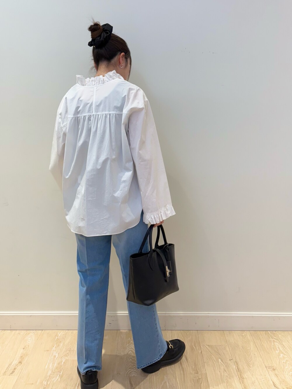 ブルー系のデニムパンツ、ブラック系のタンクトップ、ホワイト系のシャツ/ブラウスを着用したレディースの冬コーディネートの2枚目の写真