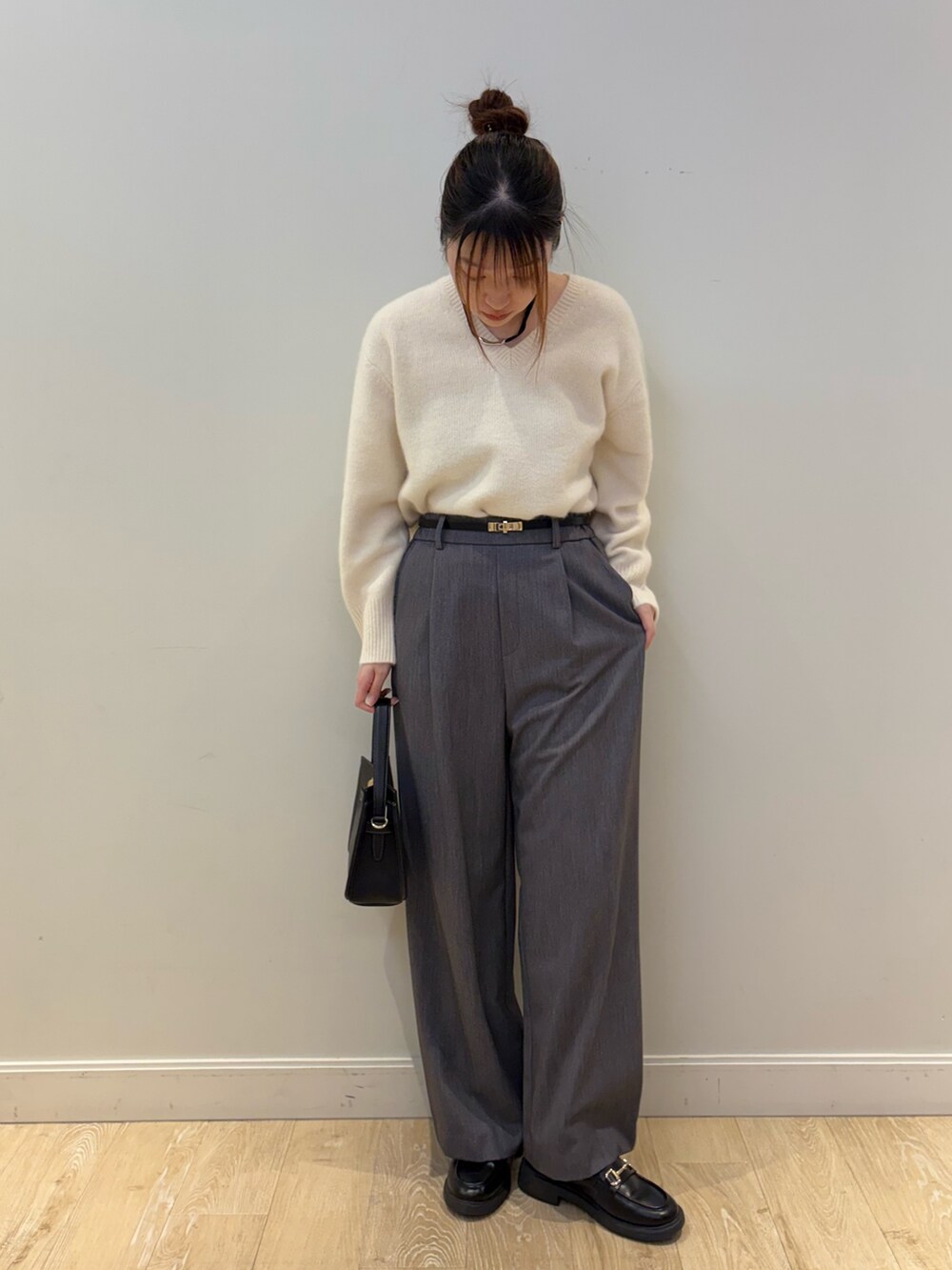 ブラック系のショルダーバッグ、ホワイト系のニット/セーター、グレー系のその他パンツを着用したレディースの秋コーディネートの4枚目の写真