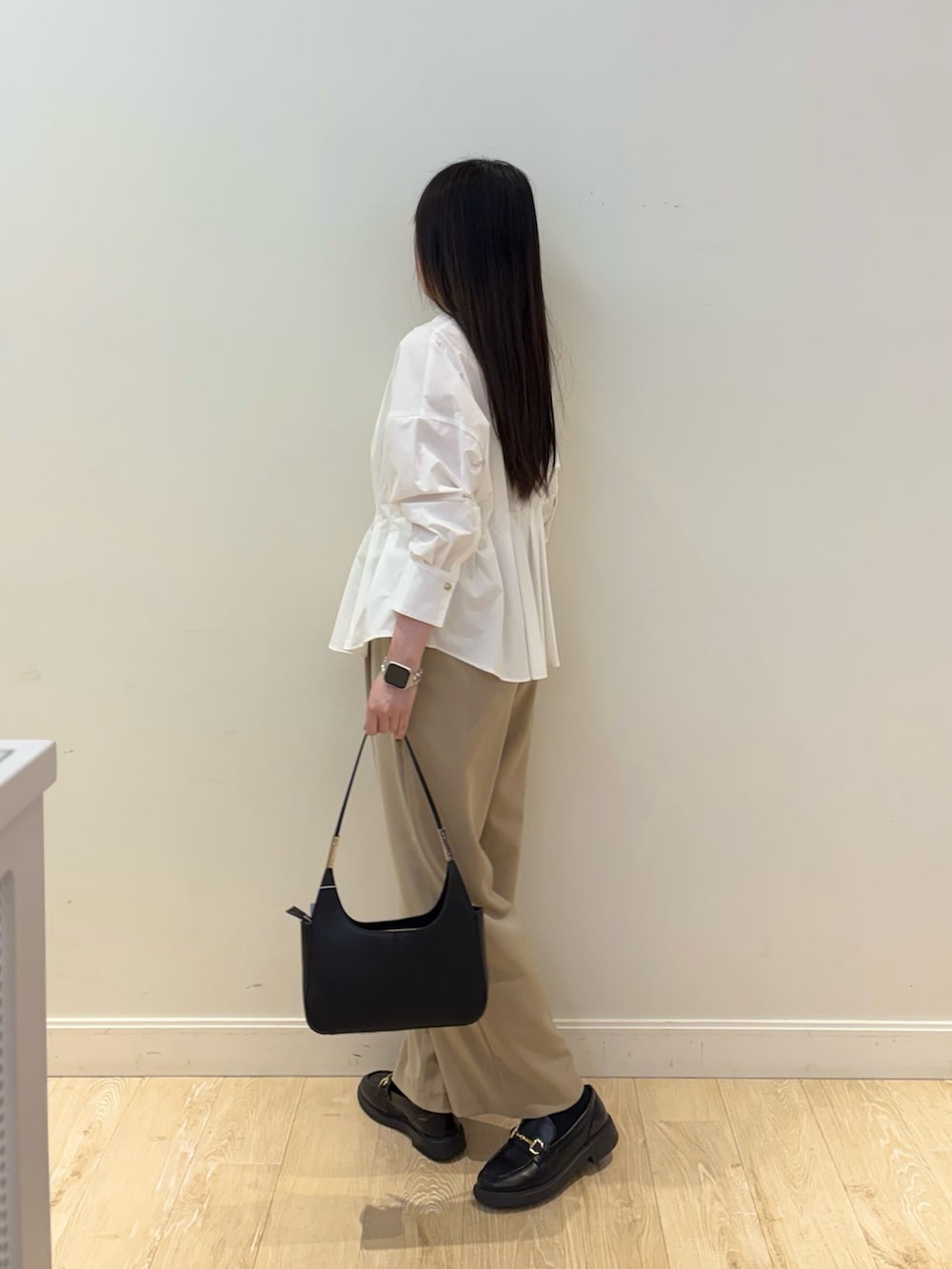ブラック系のショルダーバッグ、ベージュ系のその他パンツ、ホワイト系のシャツ/ブラウスを着用したレディースの秋コーディネートの2枚目の写真