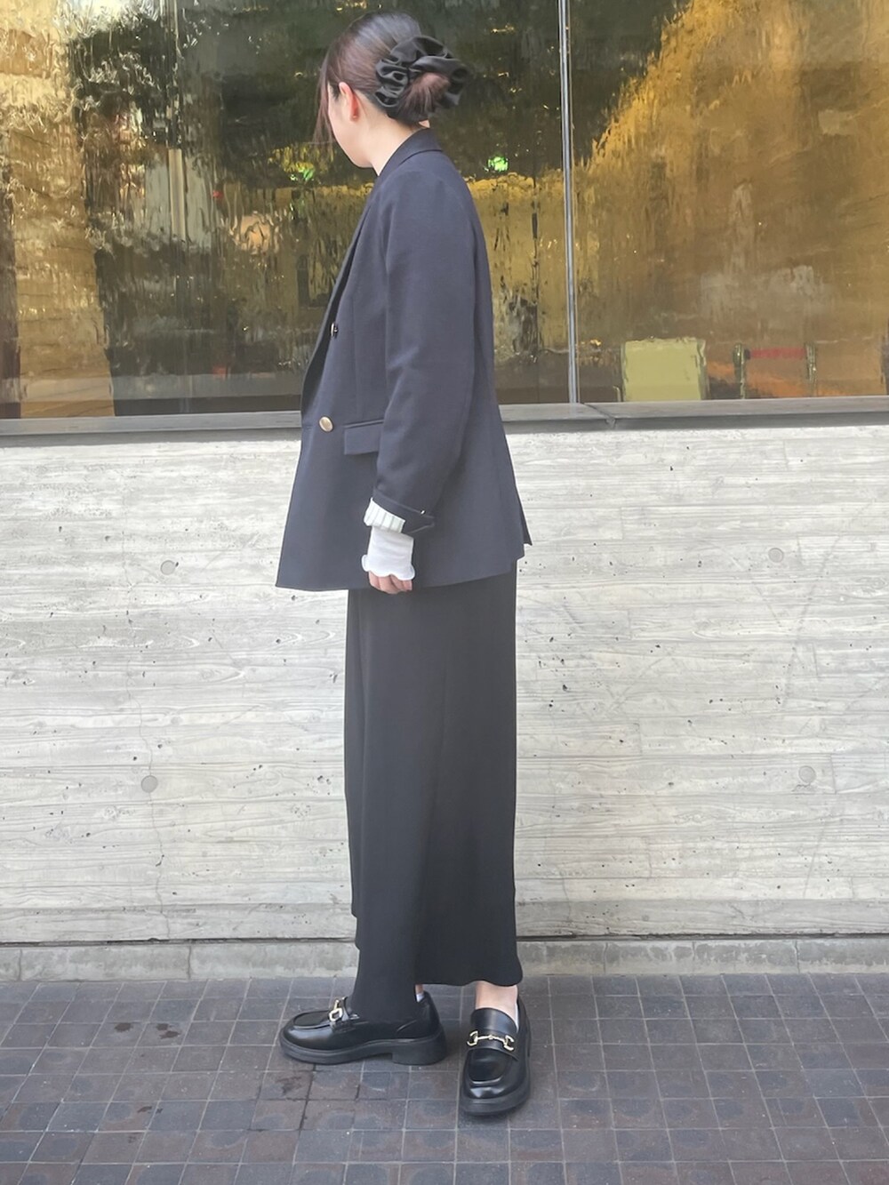 シルバー系のTシャツ/カットソー、ブラック系のスカート、ブルー系のテーラードジャケットを着用したレディースの冬コーディネートの2枚目の写真