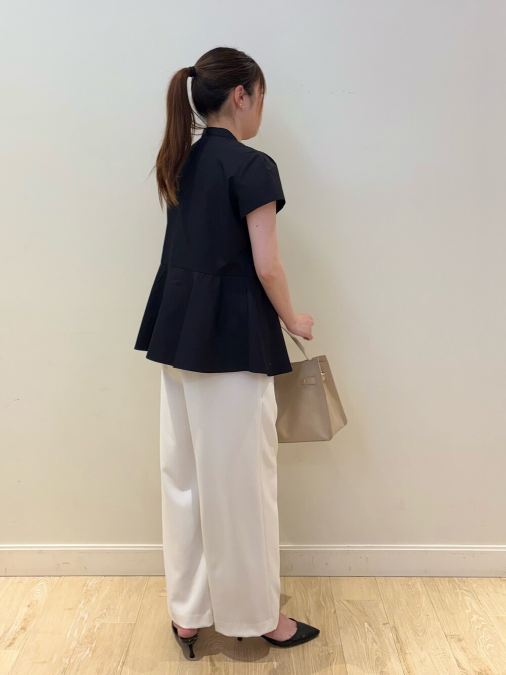 ベージュ系のトートバッグ、ホワイト系のその他パンツ、ブラック系のシャツ/ブラウスを着用したレディースの春コーディネートの2枚目の写真