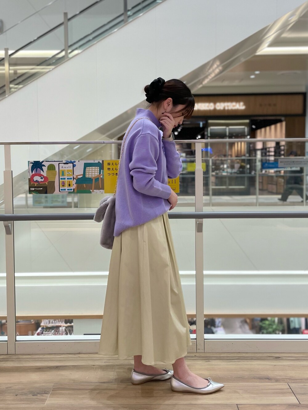 グレー系のトートバッグ、ホワイト系のニット/セーター、ベージュ系のスカートを着用したレディースの冬コーディネートの4枚目の写真