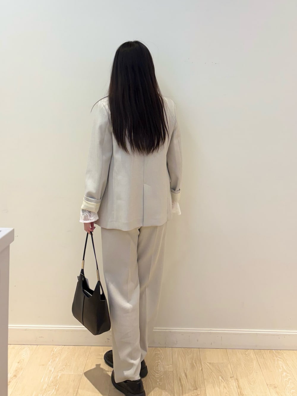 ブラック系のショルダーバッグ、ホワイト系のシャツ/ブラウス、ベージュ系のその他パンツを着用したレディースの秋コーディネートの3枚目の写真