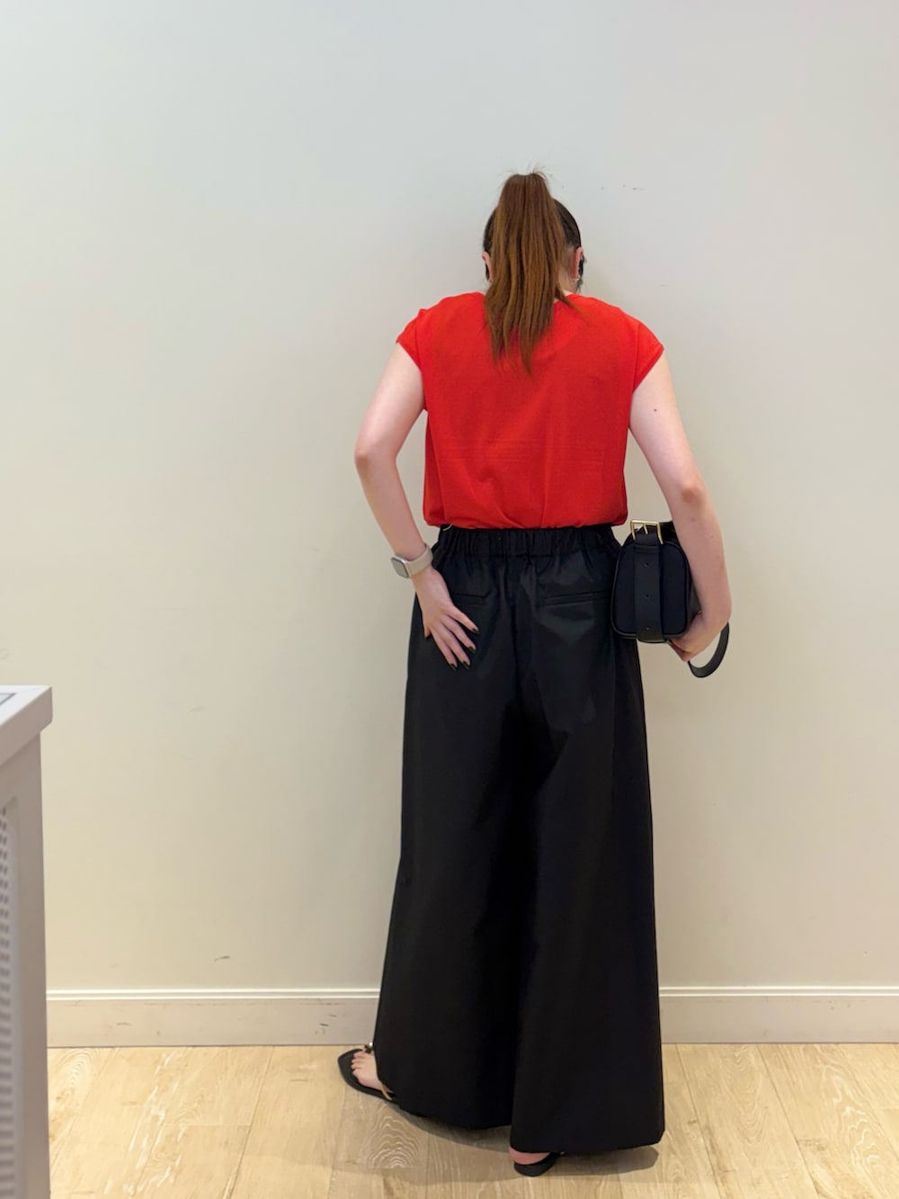 ブラック系のその他パンツ、ブラック系のショルダーバッグ、レッド系のニット/セーターを着用したレディースの夏コーディネートの2枚目の写真