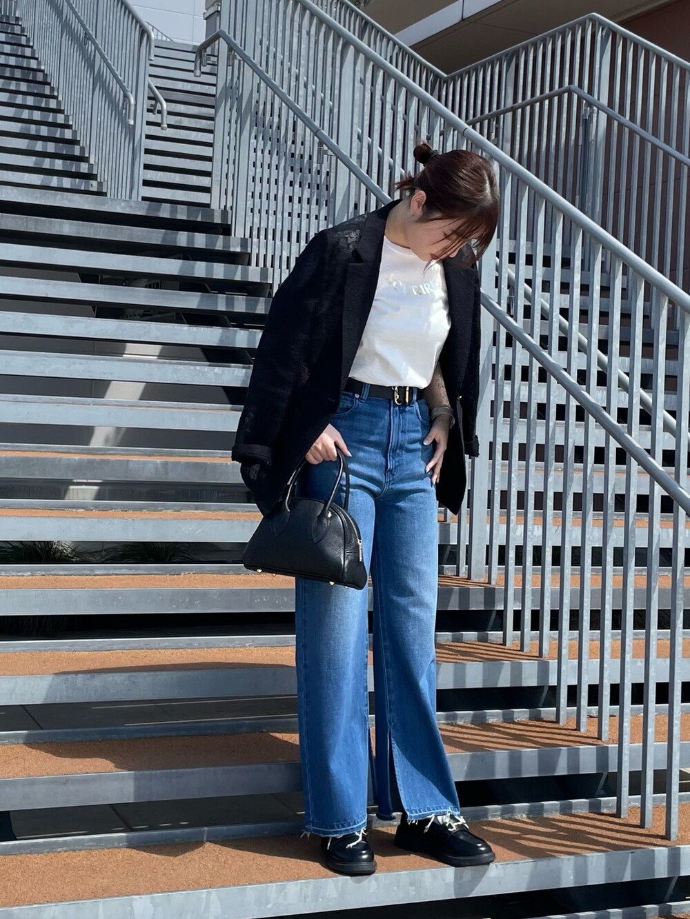 ホワイト系のTシャツ/カットソー、ブラック系のボストンバッグ、ブルー系のデニムパンツを着用したレディースの春コーディネートの5枚目の写真
