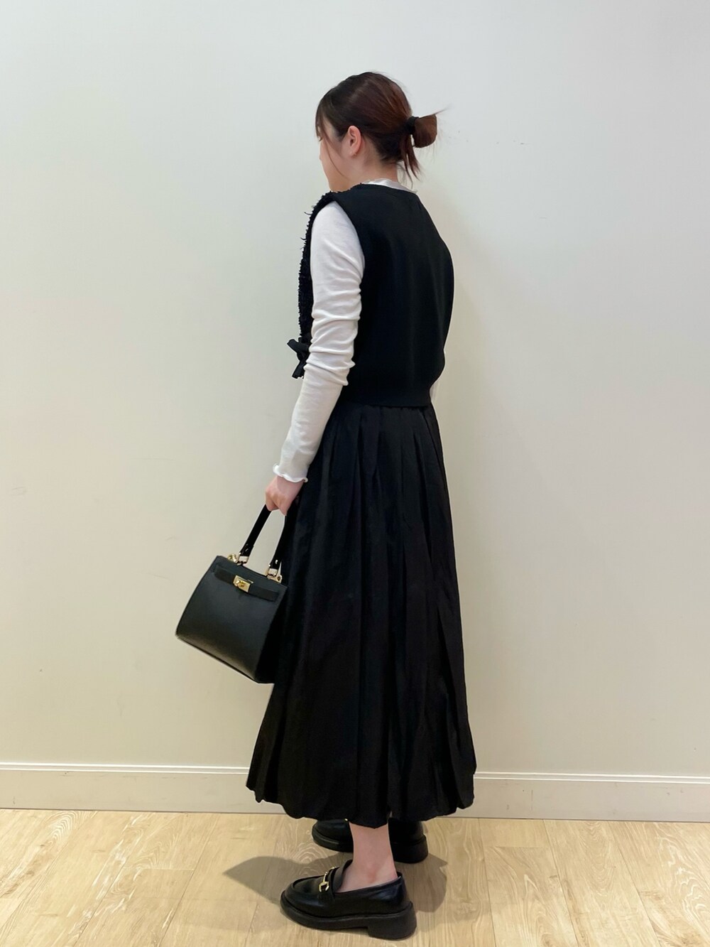 ブラック系のショルダーバッグ、シルバー系のTシャツ/カットソー、ブラック系のベストを着用したレディースの春コーディネートの5枚目の写真