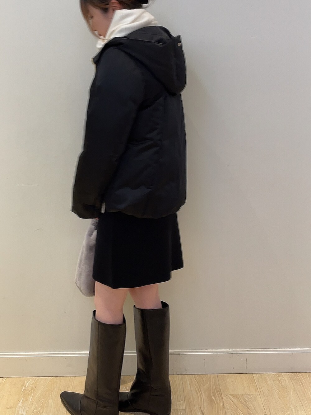 ホワイト系のニット/セーター、ブラック系のダウンジャケット/コート、ブラック系のスカートを着用したレディースの冬コーディネートの4枚目の写真