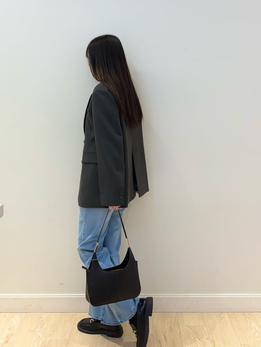 ブラック系のショルダーバッグ、ブルー系のデニムパンツ、ピンク系のTシャツ/カットソーを着用したレディースの秋コーディネートの3枚目の写真