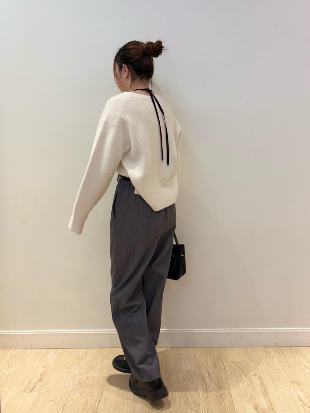 ブラック系のショルダーバッグ、ホワイト系のニット/セーター、グレー系のその他パンツを着用したレディースの秋コーディネートの3枚目の写真