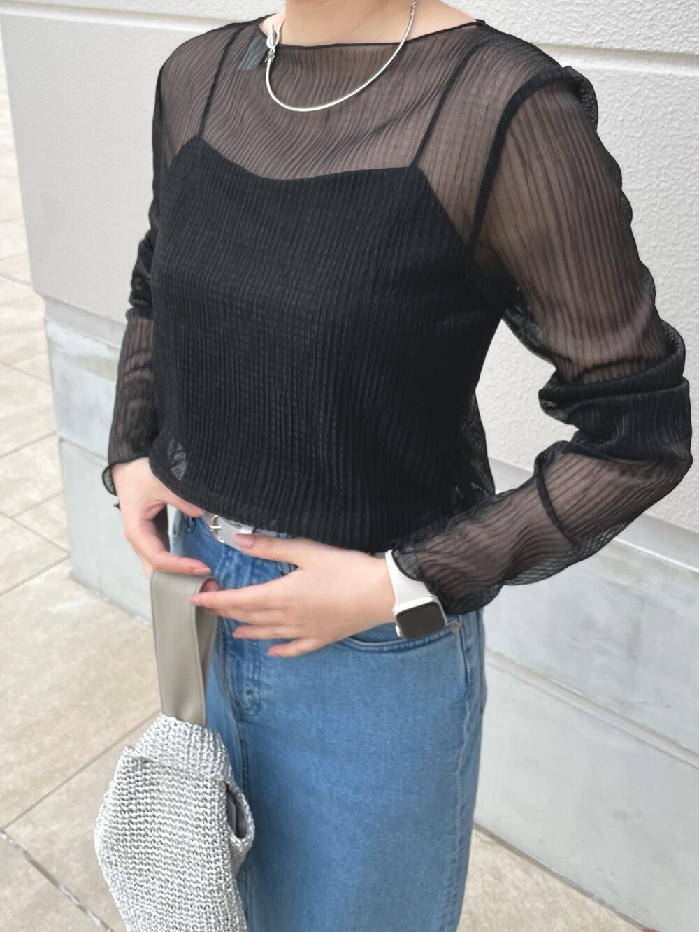 シルバー系のショルダーバッグ、シルバー系のサンダル、ブラック系のTシャツ/カットソーを着用したレディースの春コーディネートの5枚目の写真