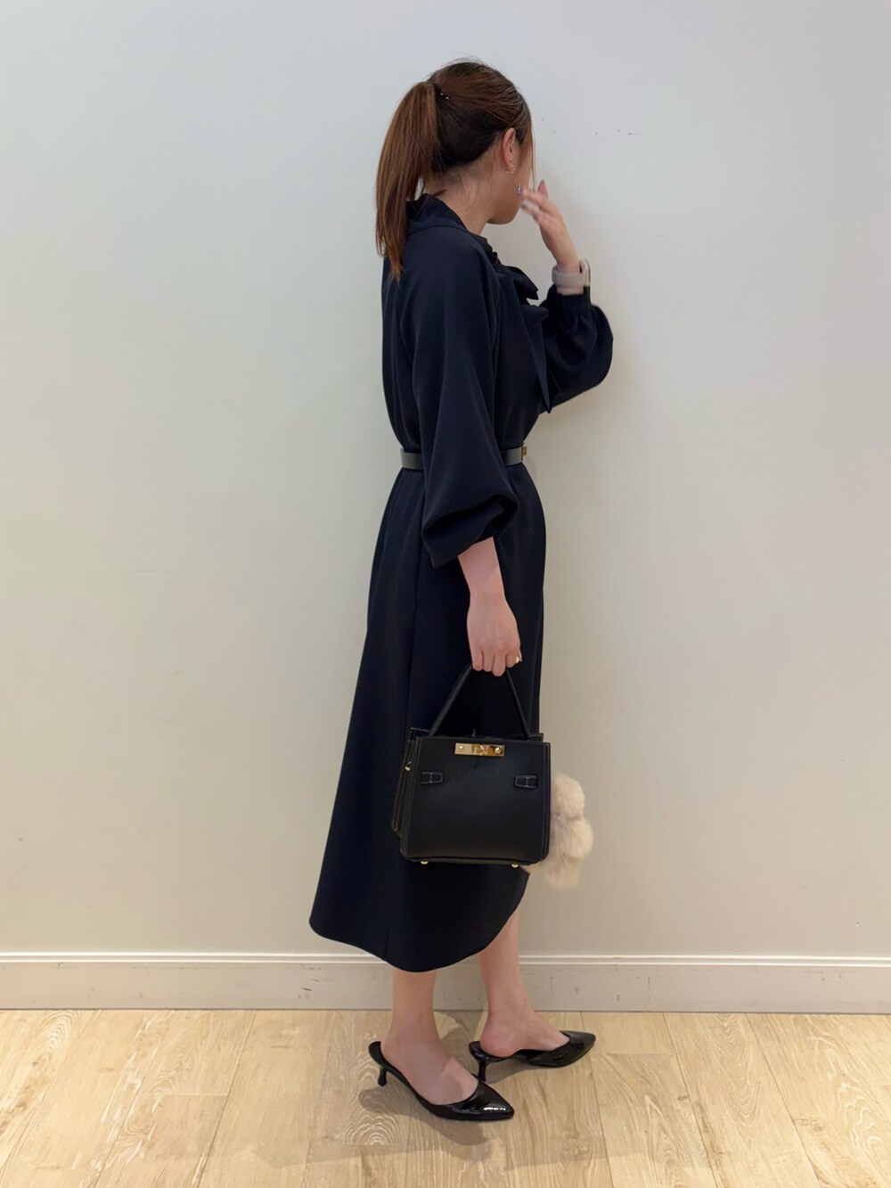 ブラック系のショルダーバッグ、ブルー系のワンピース、ブラック系のベルトを着用したレディースの秋コーディネートの2枚目の写真