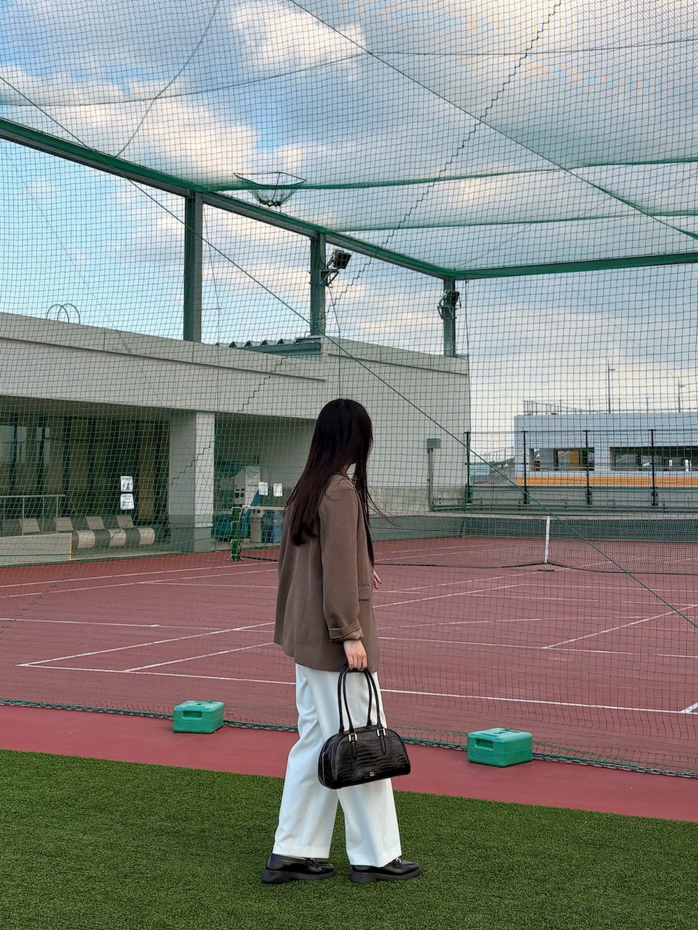 ブラック系のボストンバッグ、ホワイト系のその他パンツ、レッド系のニット/セーターを着用したレディースの秋コーディネートの3枚目の写真