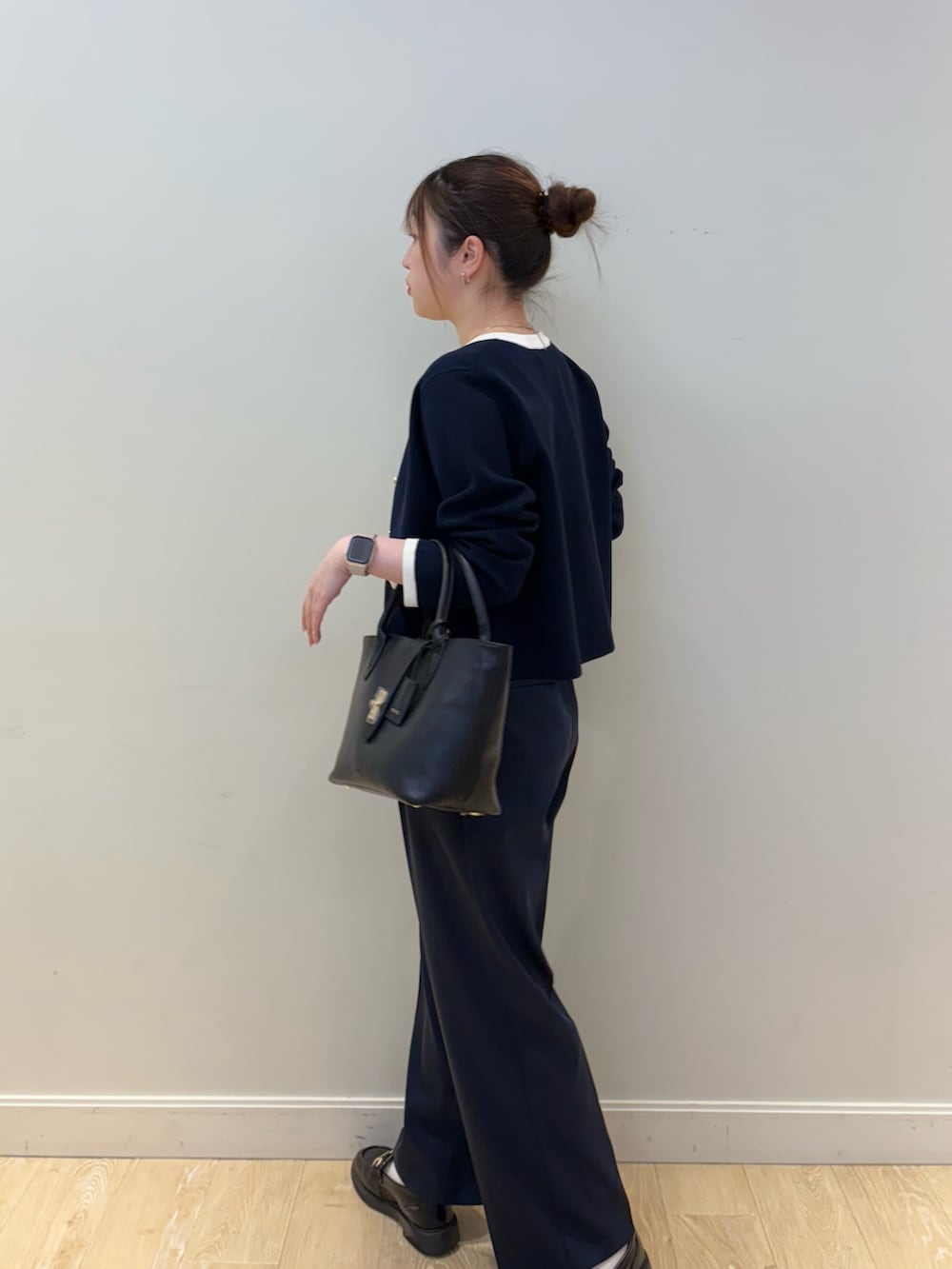 ブラック系のトートバッグ、ホワイト系のタンクトップ、ブルー系のカーディガン/ボレロを着用したレディースの春コーディネートの3枚目の写真