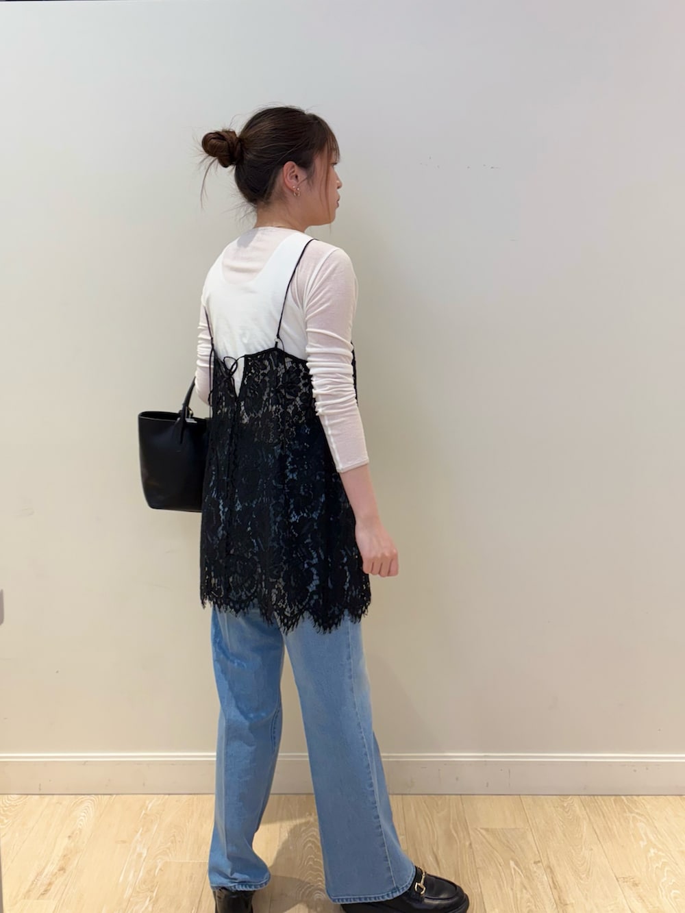 ブラック系のトートバッグ、ブルー系のデニムパンツ、ブラック系のキャミソールを着用したレディースの春コーディネートの3枚目の写真