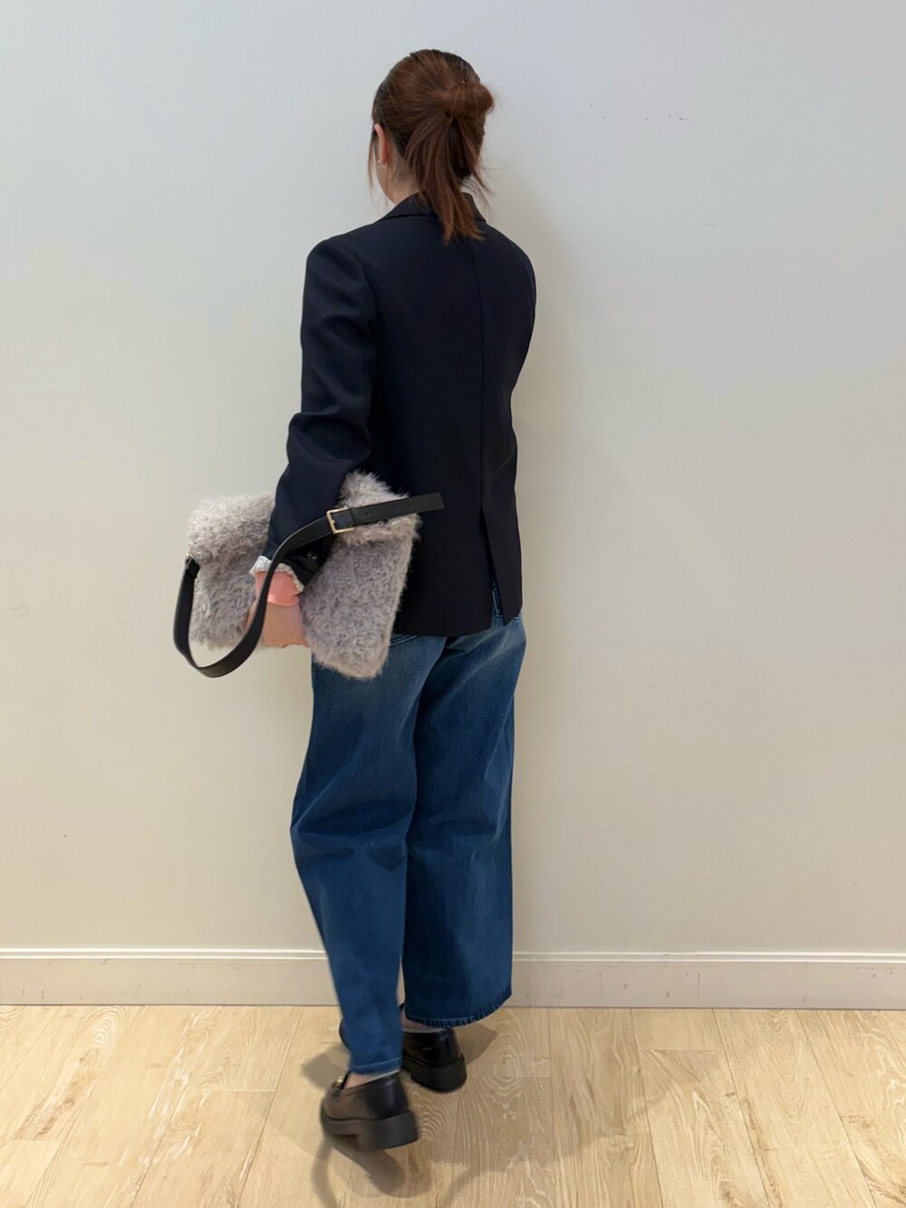 ブルー系のデニムパンツ、ベージュ系のショルダーバッグ、ピンク系のニット/セーターを着用したレディースの秋コーディネートの3枚目の写真