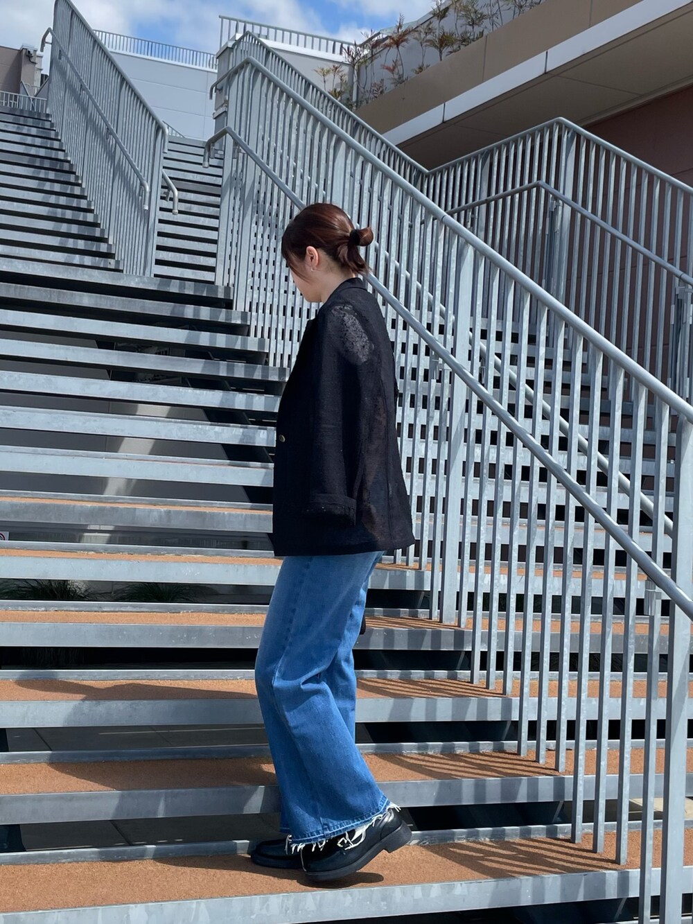 ホワイト系のTシャツ/カットソー、ブラック系のボストンバッグ、ブルー系のデニムパンツを着用したレディースの春コーディネートの3枚目の写真