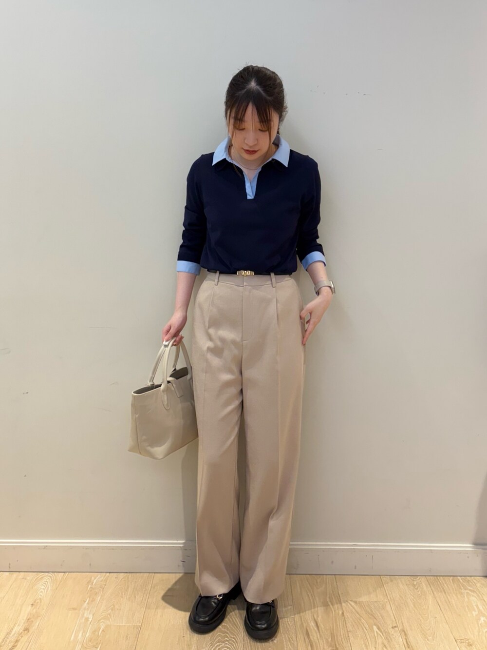 ベージュ系のその他パンツ、ブラック系のトートバッグ、ブルー系のニット/セーターを着用したレディースの春コーディネートの3枚目の写真