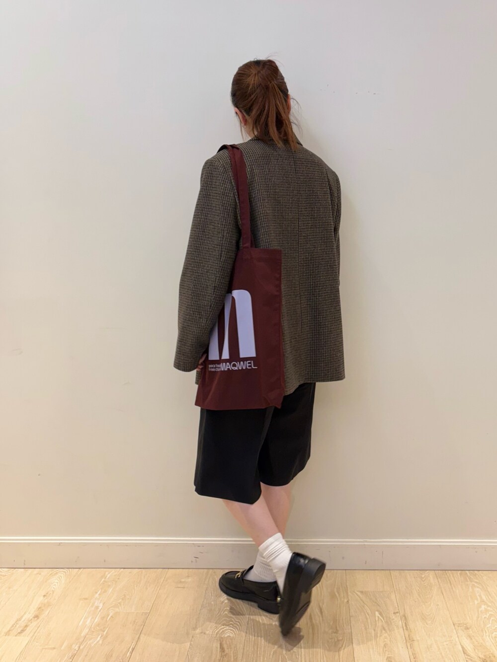レッド系のトートバッグ、ブラック系のその他パンツ、ブラウン系のTシャツ/カットソーを着用したレディースの秋コーディネートの3枚目の写真
