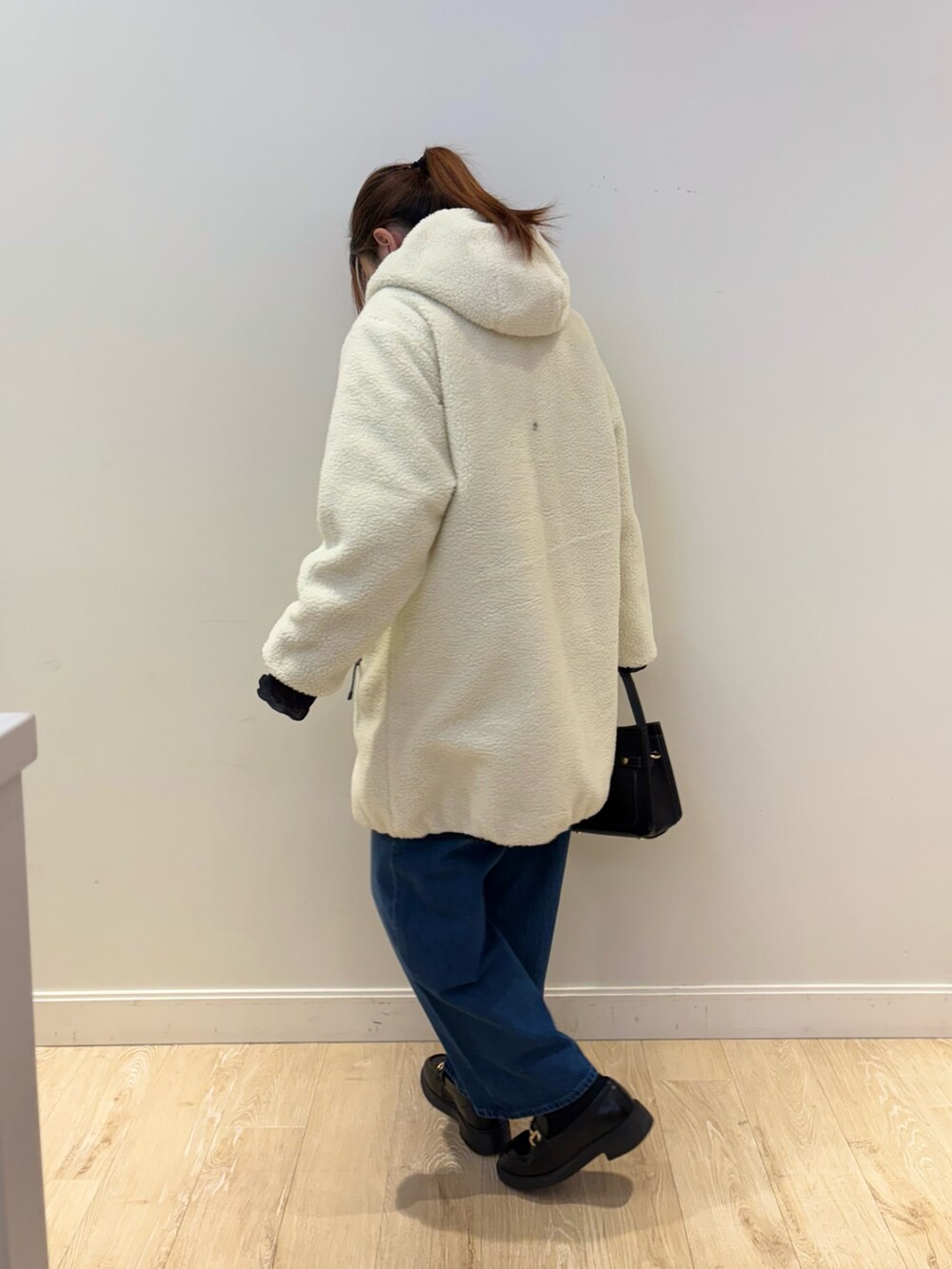 ブラック系のショルダーバッグ、ブルー系のデニムパンツ、ブラック系のTシャツ/カットソーを着用したレディースの秋コーディネートの2枚目の写真