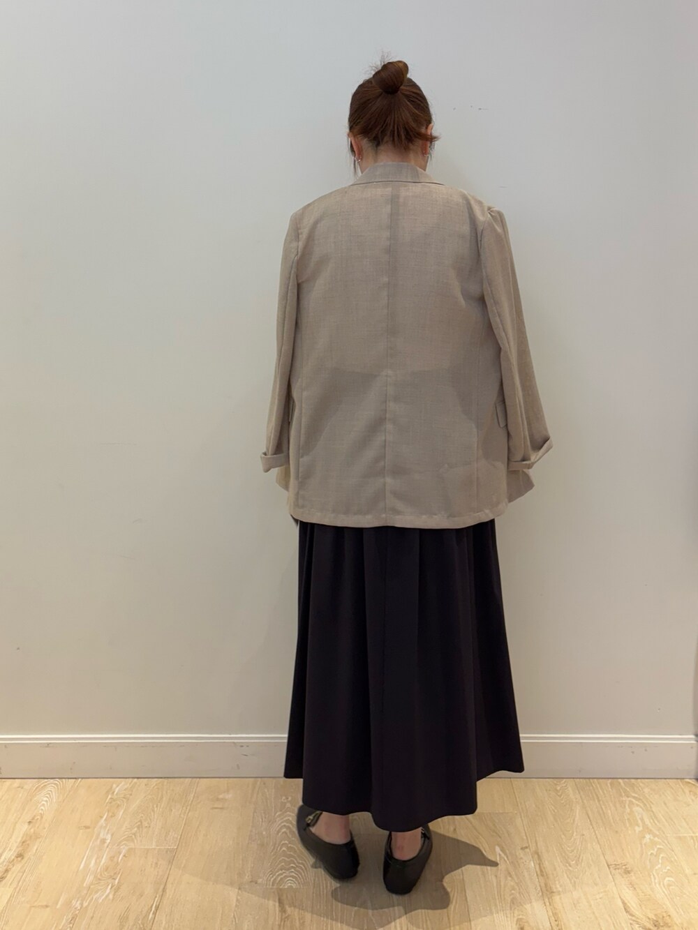 ブラック系のワンピース、ブラック系のトートバッグ、ベージュ系のテーラードジャケットを着用したレディースの夏コーディネートの2枚目の写真