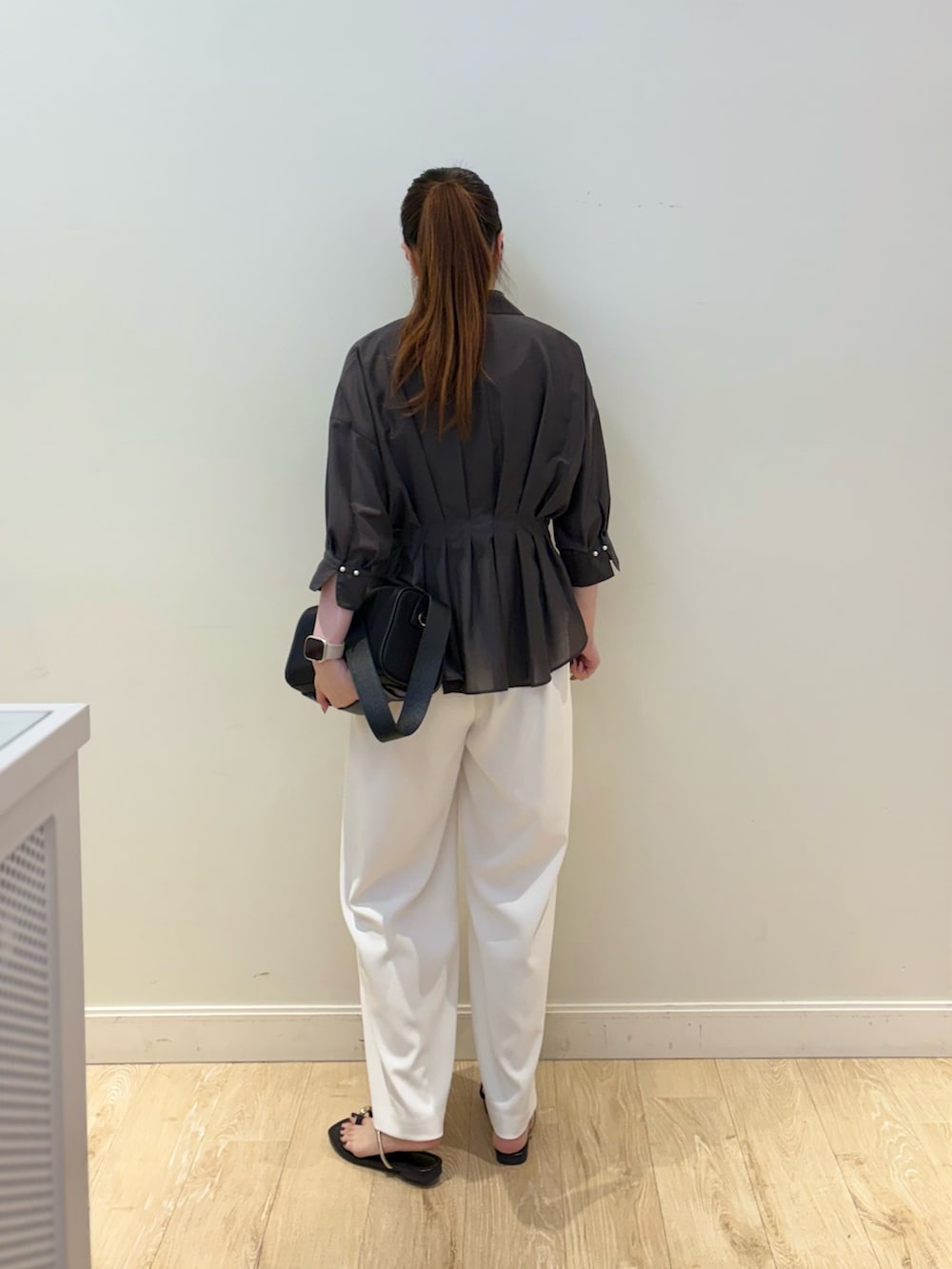 ブラック系のタンクトップ、ブラック系のショルダーバッグ、ホワイト系のその他パンツを着用したレディースの夏コーディネートの2枚目の写真