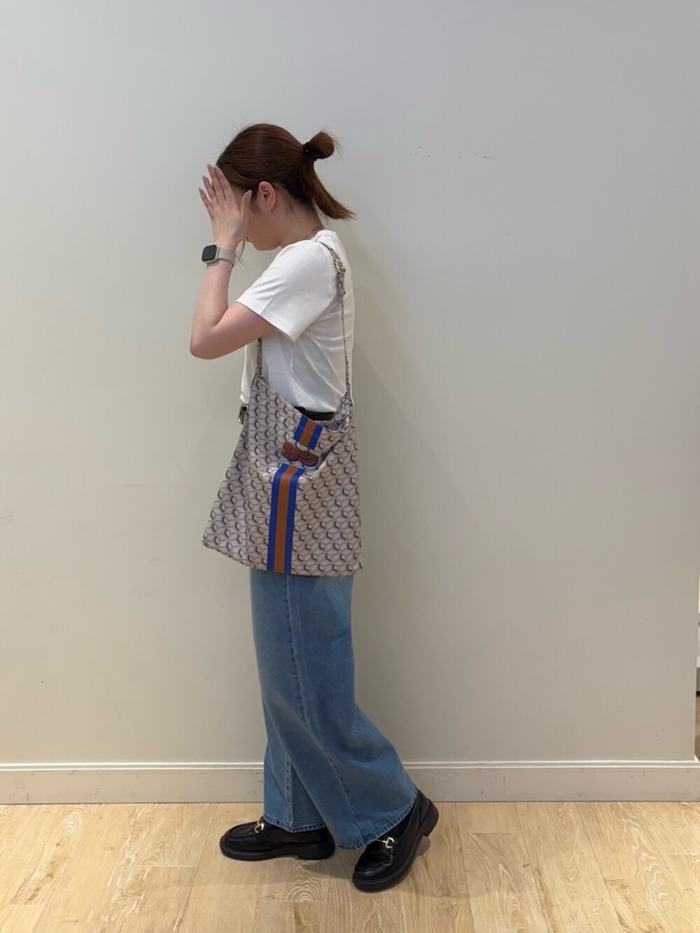 ブルー系のデニムパンツ、ブルー系のショルダーバッグ、ホワイト系のTシャツ/カットソーを着用したレディースの夏コーディネートの2枚目の写真