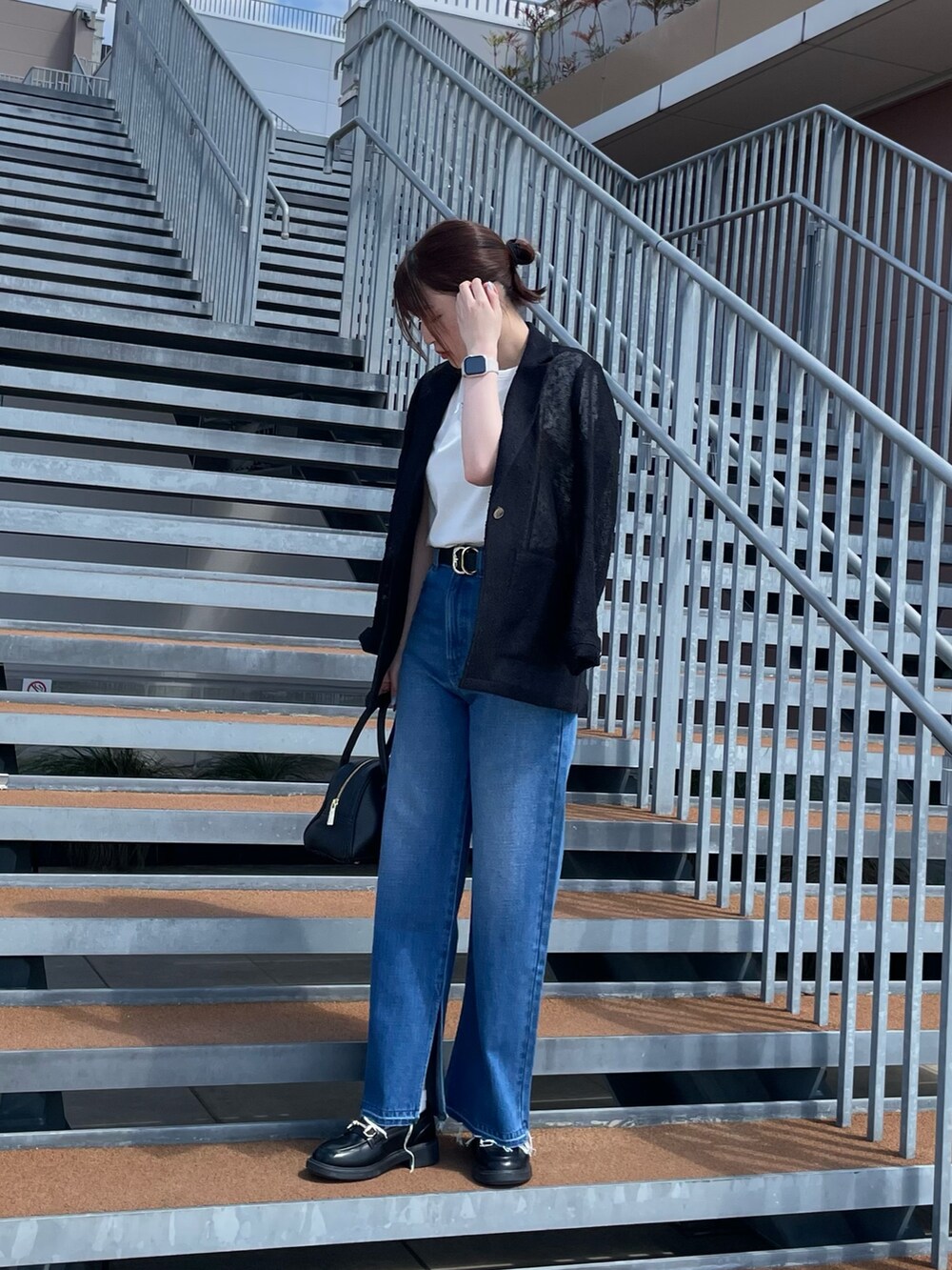 ホワイト系のTシャツ/カットソー、ブラック系のボストンバッグ、ブルー系のデニムパンツを着用したレディースの春コーディネートの2枚目の写真