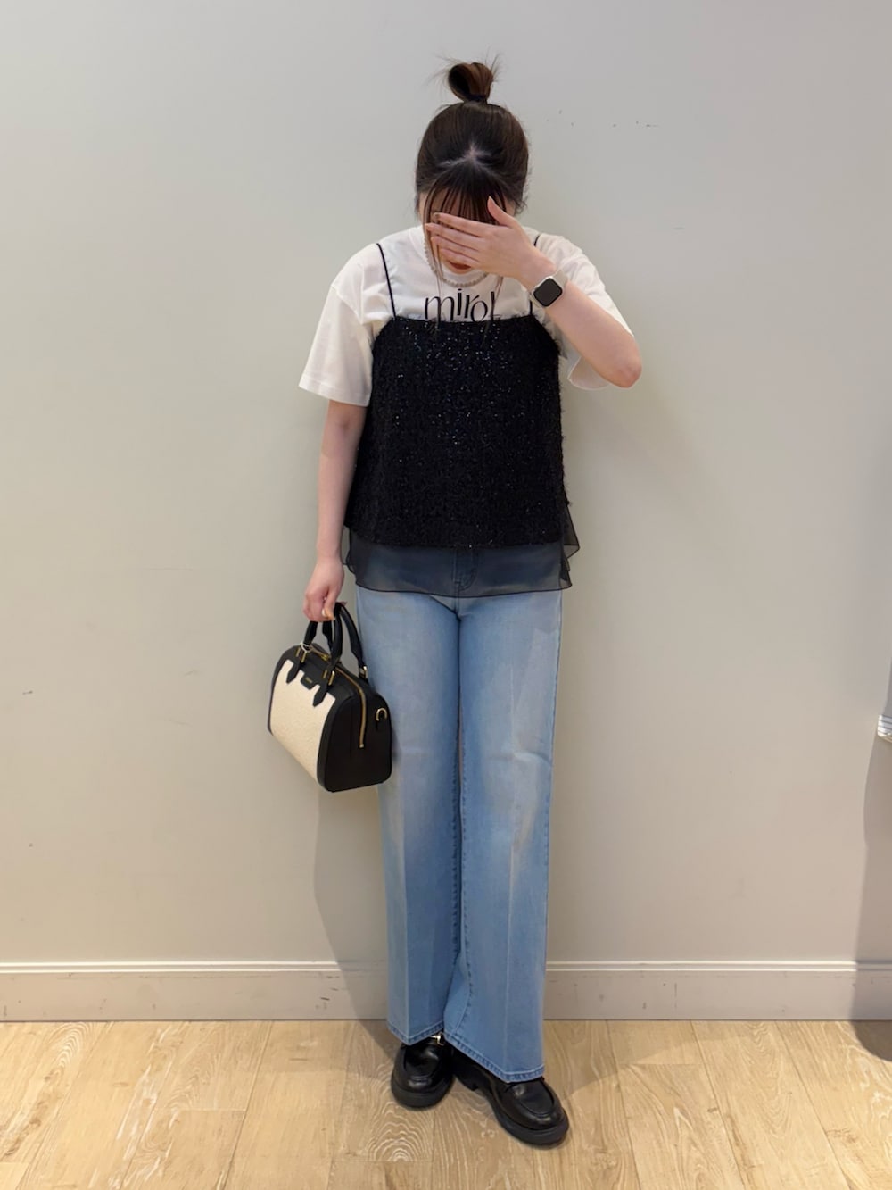 ブラック系のボストンバッグ、ホワイト系のTシャツ/カットソー、ブラック系のシャツ/ブラウスを着用したレディースの春コーディネートの4枚目の写真